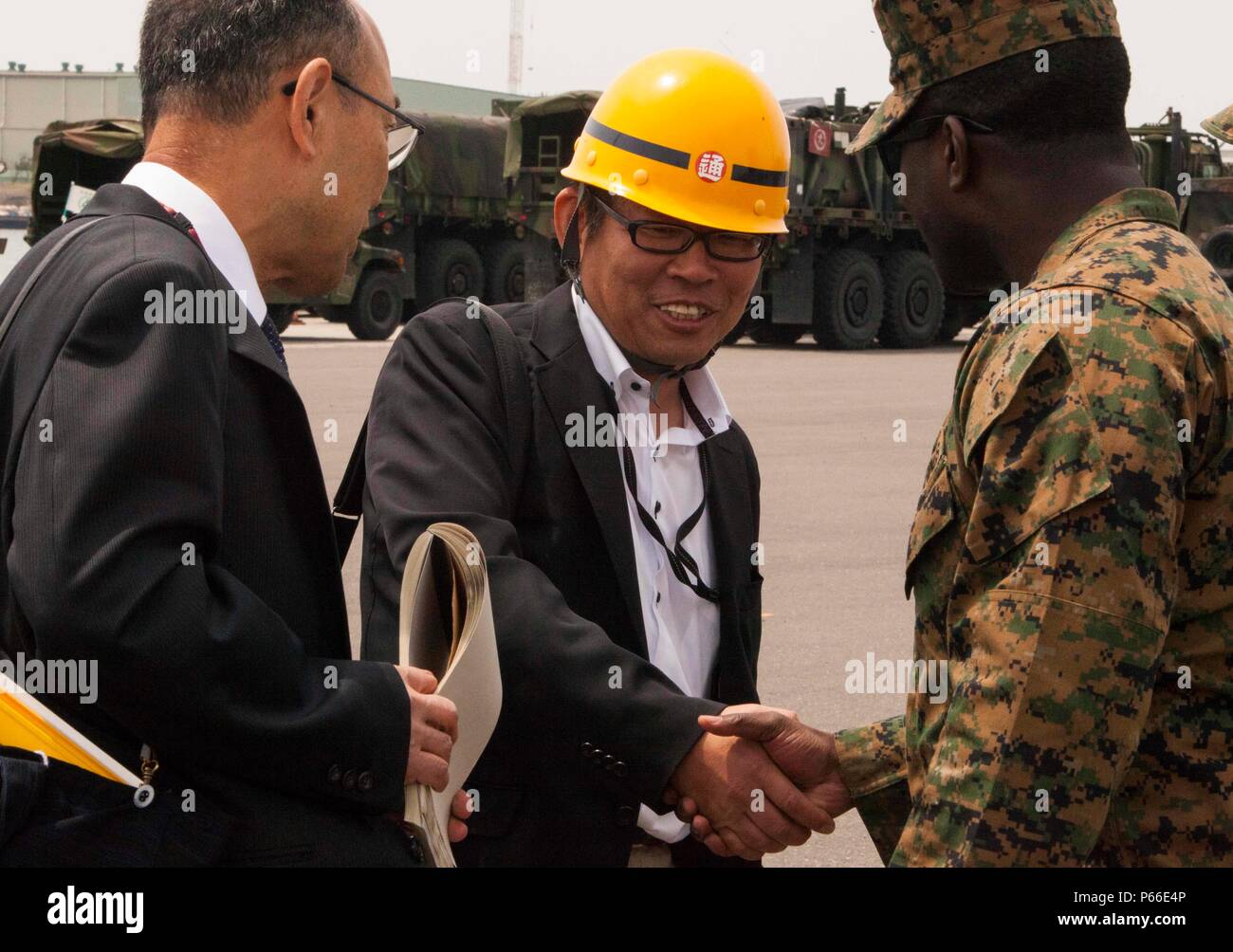 SENDAI, Japan - Kapitän Emmanuel Stimmen, der Offizier die Übung für die Artillerie Relocation Training Programm 16-1 arbeitet mit japanischen Einschiffung Fremdfirmen das Entladen der Artillerie in Sendai Port Überwachung am 9. Mai 2016. Stimmen ist mit 3.Bataillon, 12 Marine Regiment, 3rd Marine Division, III Marine Expeditionary Force in Camp Hansen, Okinawa, Japan beruht und sich von Washington, D.C. Stockfoto