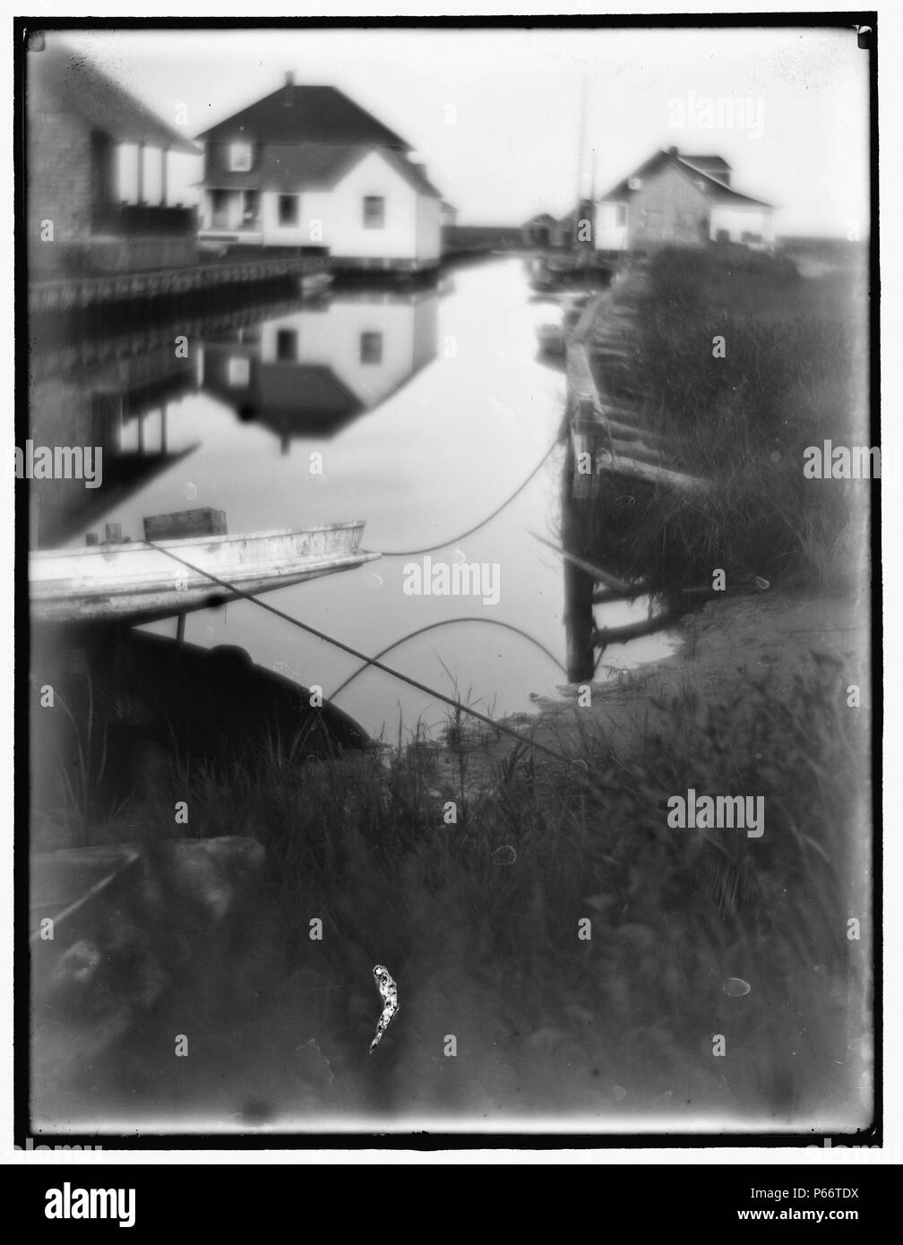 Bungalows am Wasser in Oceanside. von Gertrude Käsebier 1852-1934, Fotograf. Datiert von 1905. Kleine Passage von Wasser durch Häuser und Docks flankiert. Stockfoto