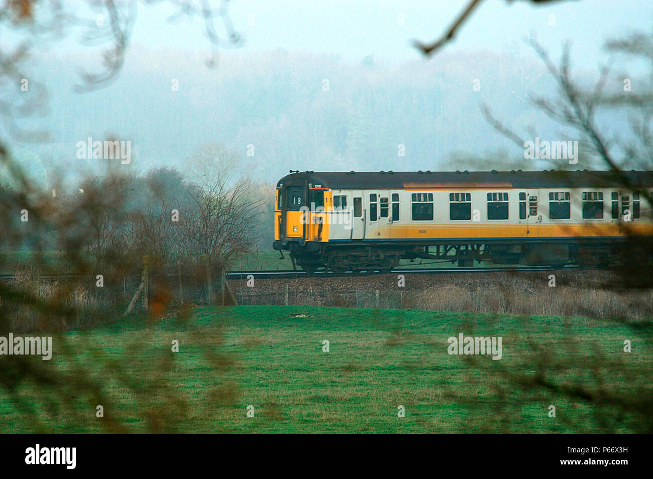 Ein verbindungsfähiges Livrierten Klasse 421/3, 4 Cig. Mit knall Tür Lager Geschwindigkeit durch die Landschaft von Sussex. 2003 Stockfoto