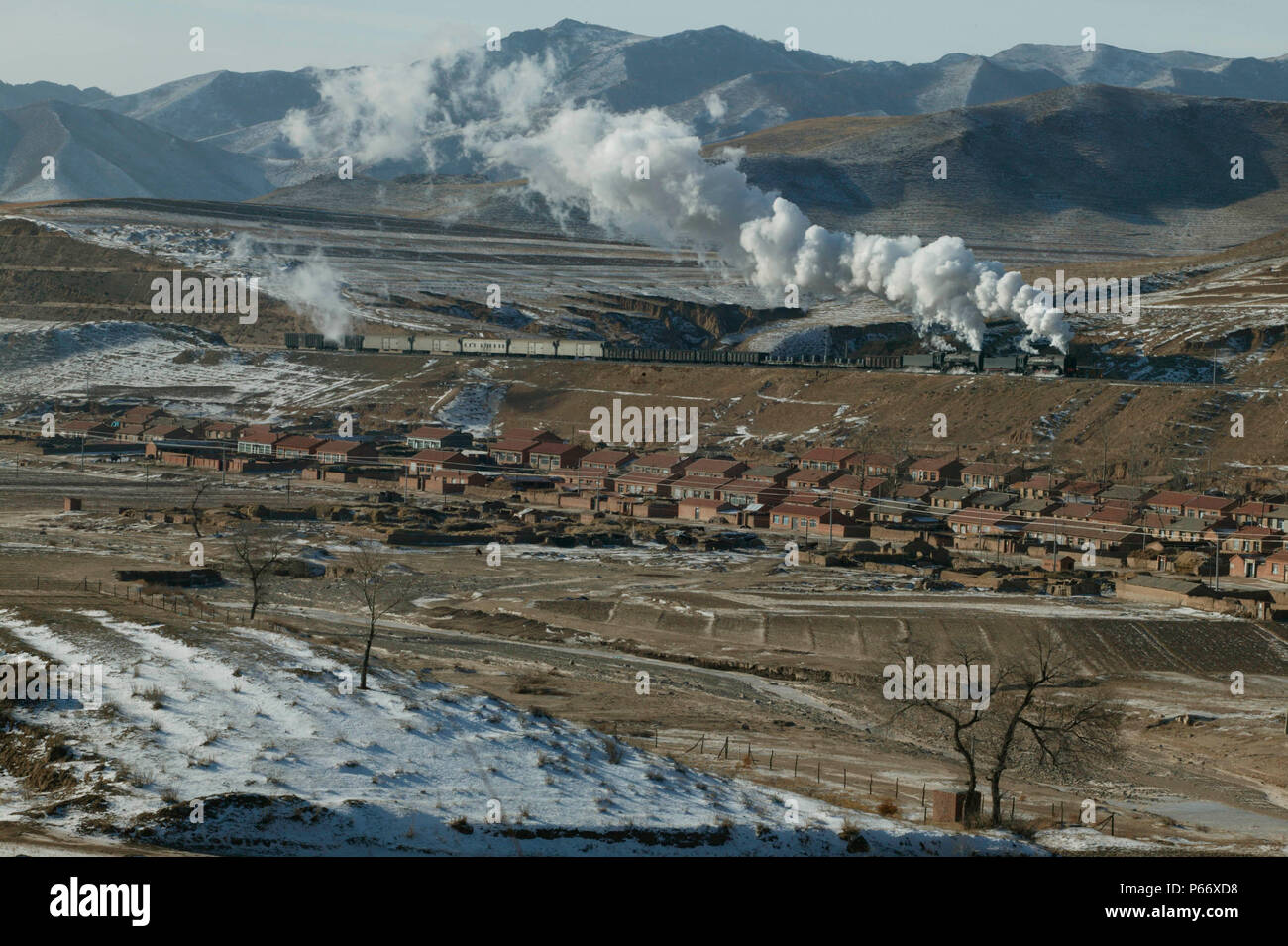 Eine eastbound Fracht von Holoku zu Daban übergibt das Dorf von Xiakengzi auf dem Jing Peng Pass Abschnitt des Ji-Tong Eisenbahn, der Inneren Mongolei. Die mi Stockfoto