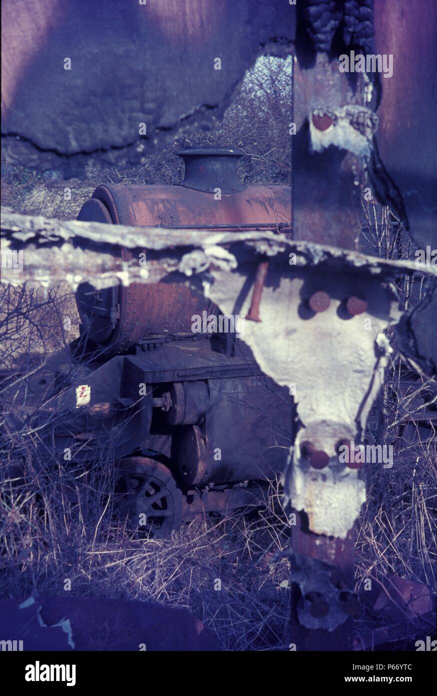 Rost und Gebrannte Umbra. Ein stanier Black Five durch eine ausgebrannte Guard van bei Cohen's breakers Yard, Cransley, Kettering gesehen. Stockfoto