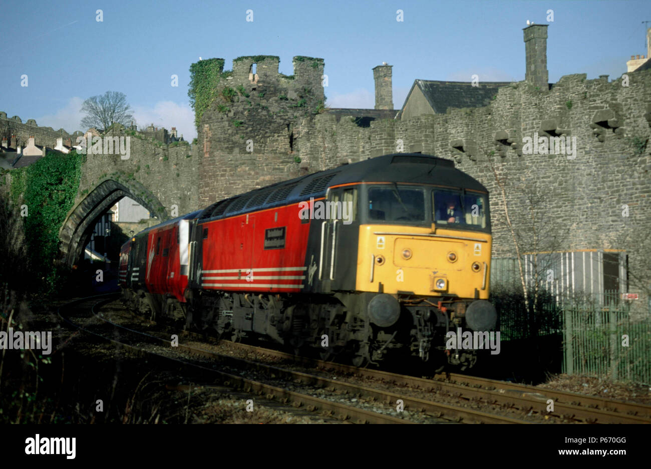 Die Institution der Maschinenbauingenieure, Nr. 47841, schleppt eine Jungfrau West Coast Service weg von Conwy station en-route nach Holyhead. (Westküste) Stockfoto