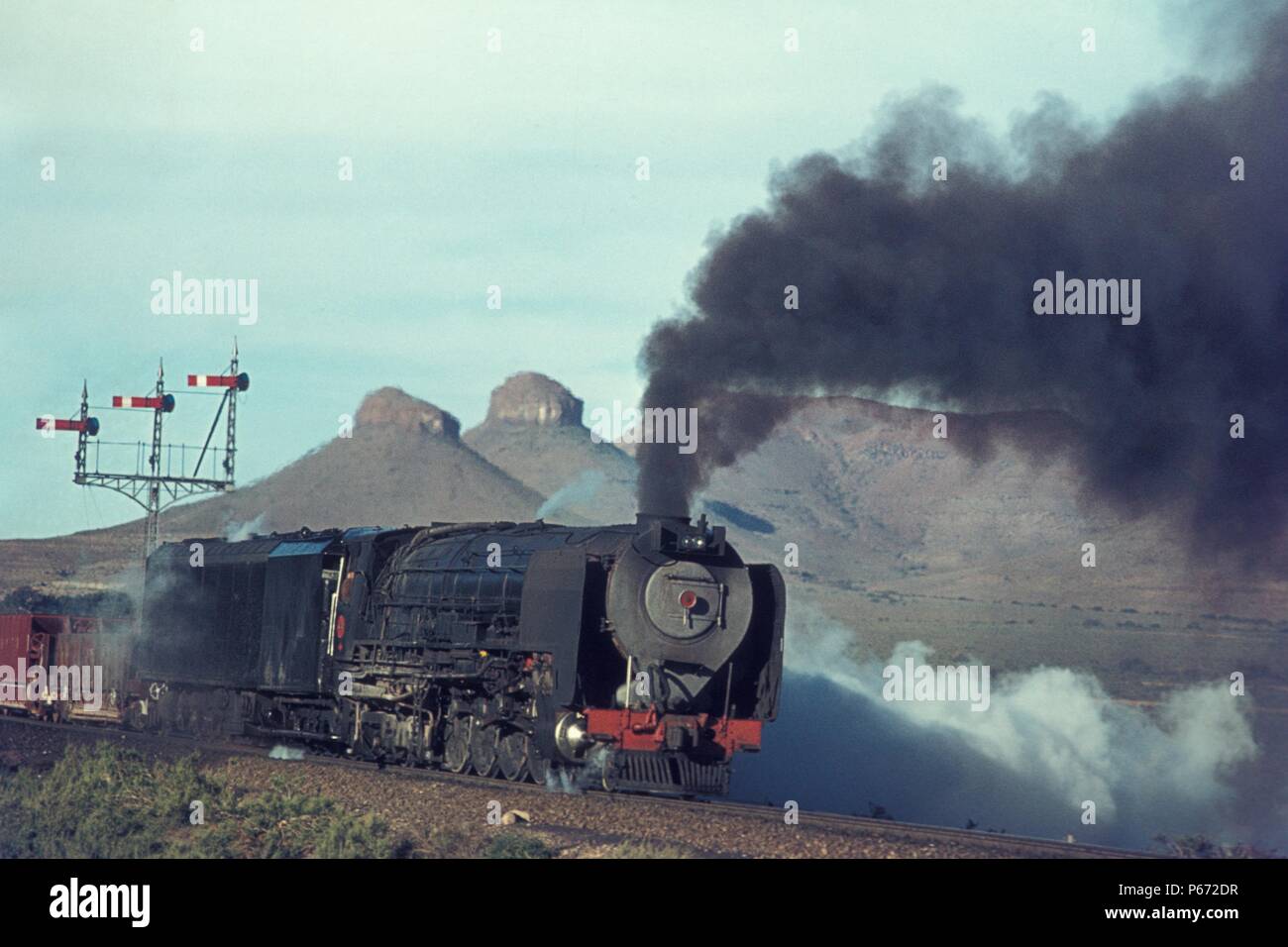 Eine südafrikanische Eisenbahnen Kondensator 4-8-4 Klasse 25 an drei Schwestern in der karroo Wüste. Juni 1973. Stockfoto