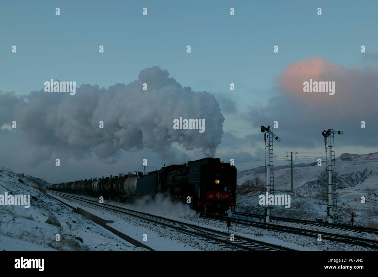 Eine eastbound Rake von Öltankschiffen zieht stark weg von Shandian auf dem Jing Peng pass Abschnitt von Chinas Ji-Tong Eisenbahn in der Inneren Mongolei in Decemb Stockfoto