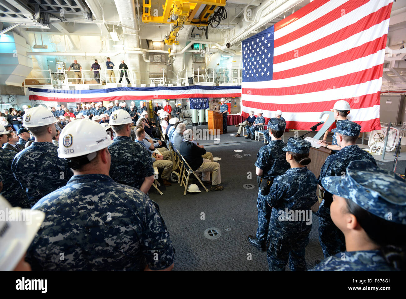 160520-N-YZ 252-112 BADEWANNE, Maine (20. Mai 2016) Kapitän James Downey, Program Manager für DDG 1000, spricht mit montierten Crew Mitglieder und Gäste im Hangar Bay an Bord der Zukunft geführte Anti-raketen-Zerstörer USS Zumwalt (DDG 1000) während der Übertragung des Eigentums Zeremonie. Die US-Marine akzeptiert Lieferung der DDG 1000, die Zukunft USS Zumwalt Zerstörer 20. Mai 2016. Nach einer Crew Zertifizierung Zeitraum und Oktober Inbetriebnahme Zeremonie in Baltimore, Zumwalt wird Transit zu seinen Heimathafen in San Diego für einen Post Lieferung Verfügbarkeit und Mission Systeme Aktivierung. DDG 1000 ist der Leitung Schiff der Zumwalt Stockfoto
