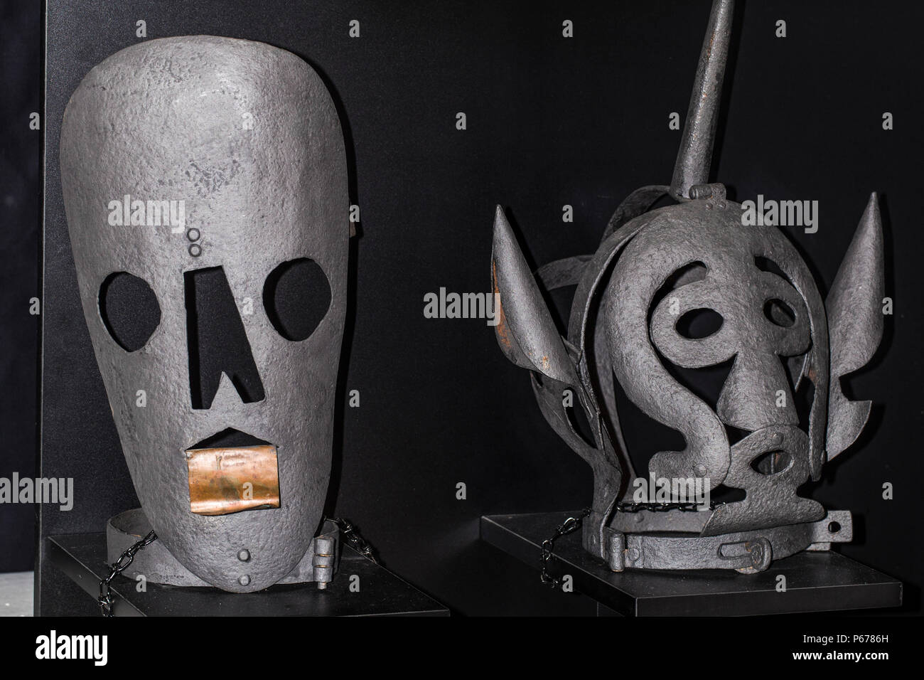 Instrumente der Folter Zeiten der Inquisition zwei grauen Masken auf schwarzem Hintergrund Stockfoto
