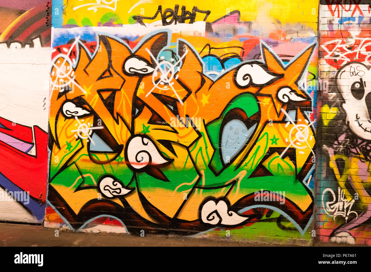 London Waterloo Leake Street Graffiti orange grün gelb Buchstaben script Wand gehsteig Bürgersteig detail Stockfoto