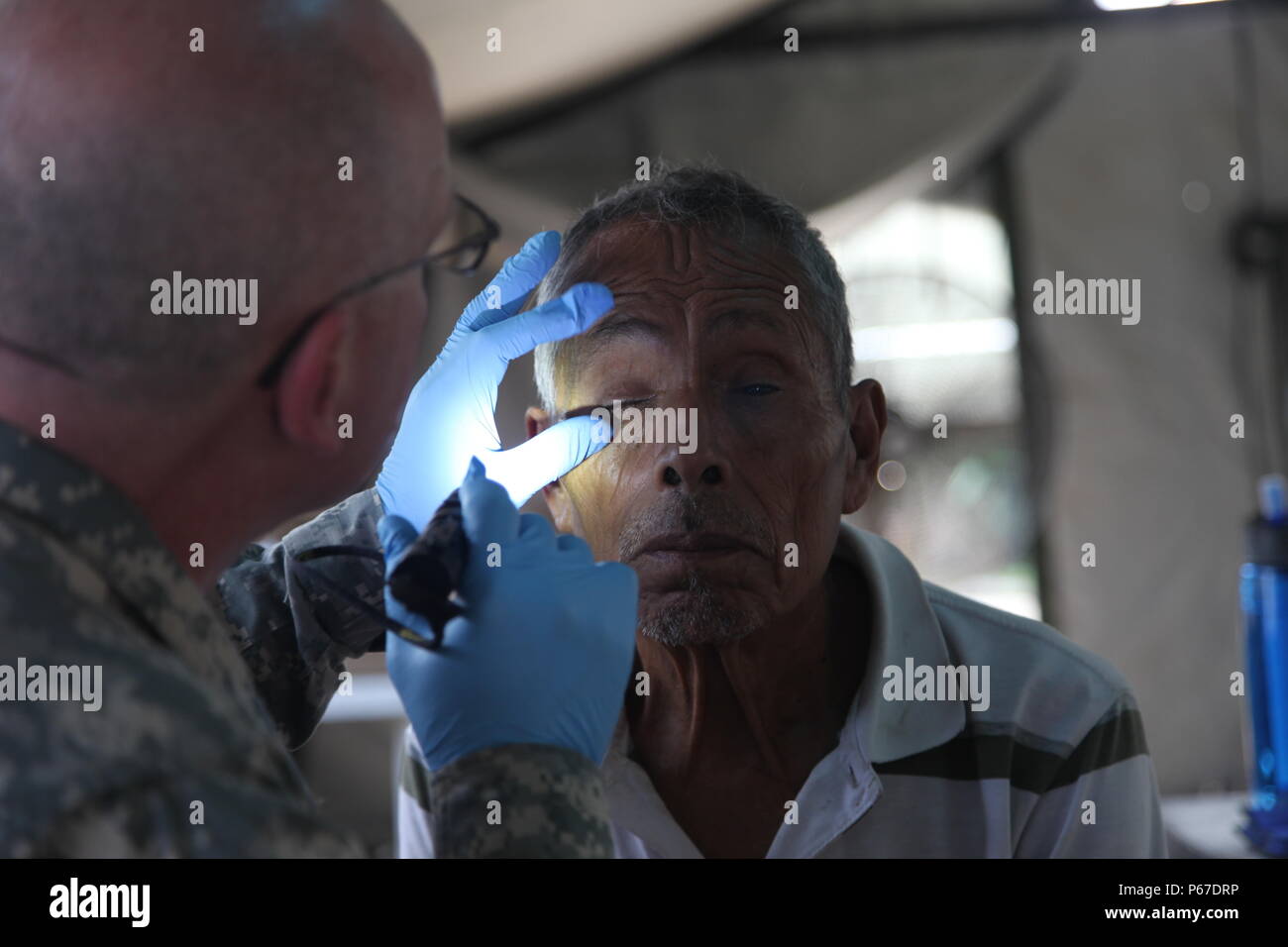 Us-Armee Kapitän Mark Dagenais, mit der 410 medizinische Logistik Unternehmen, gibt eine detaillierte Auge Prüfung der lokalen Bürger in der optometrie Zelt während einer medizinischen Readiness Training übung in San Padro, Guatemala, 10. Mai 2016. Task Force Red Wolf und Armee nach Süden führt Humanitäre Zivile Hilfe Ausbildung auf taktischer Ebene Bauprojekte und medizinische Bereitschaft Übungen medizinische Zugang und den Bau von Schulen in Guatemala mit der guatemaltekischen Regierung und nicht-staatlichen Stellen von 05 Mär 16 bis 18 Apr 16 Um die Mission die Bereitschaft der US-Streitkräfte zu verbessern und zu p gehören Stockfoto