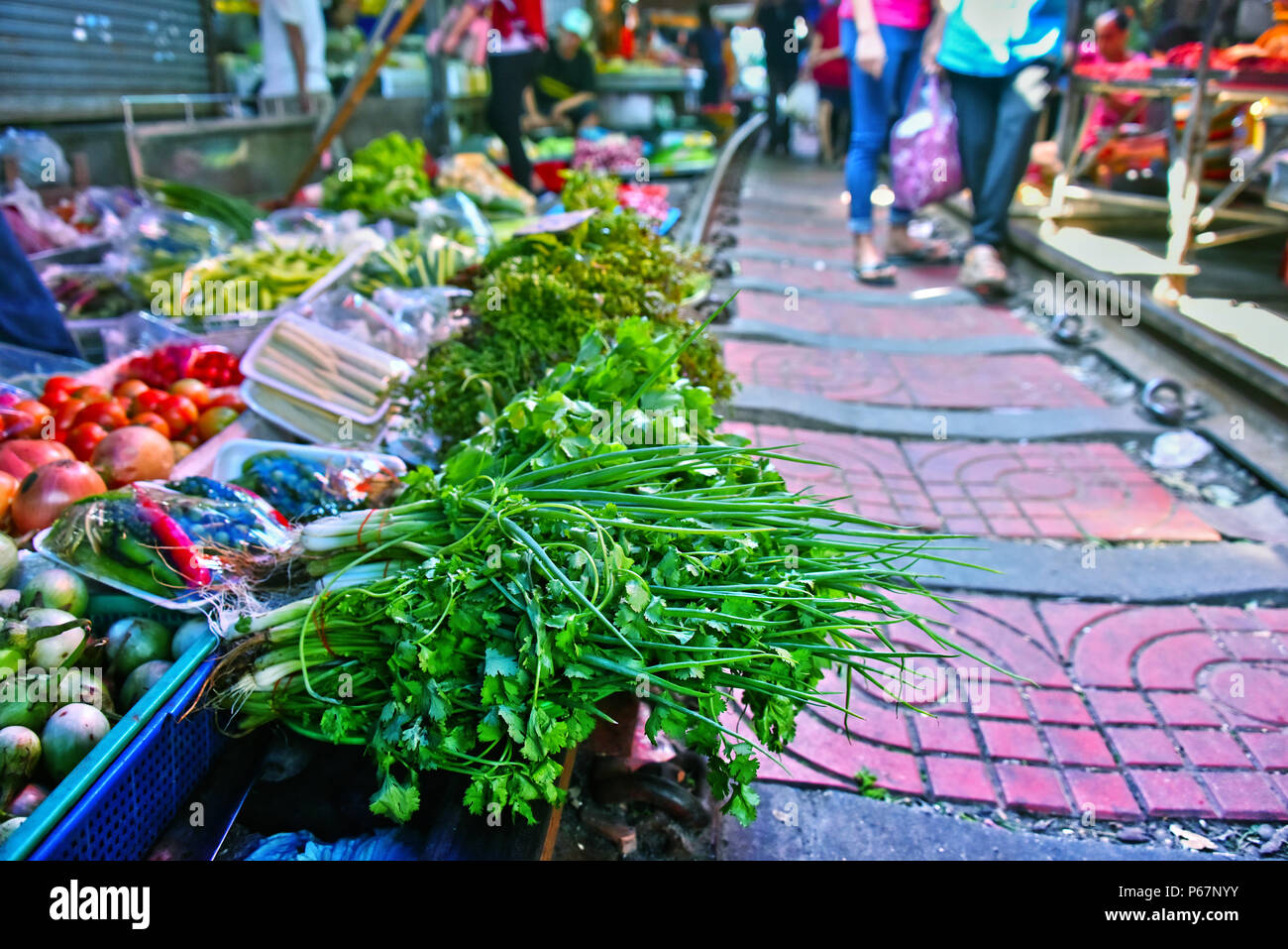 Verkauf von Speisen auf der Maeklong Railway Markt in Thailand. Stockfoto