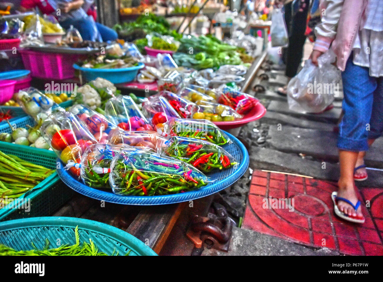 Verkauf von Speisen auf der Maeklong Railway Markt in Thailand. Stockfoto