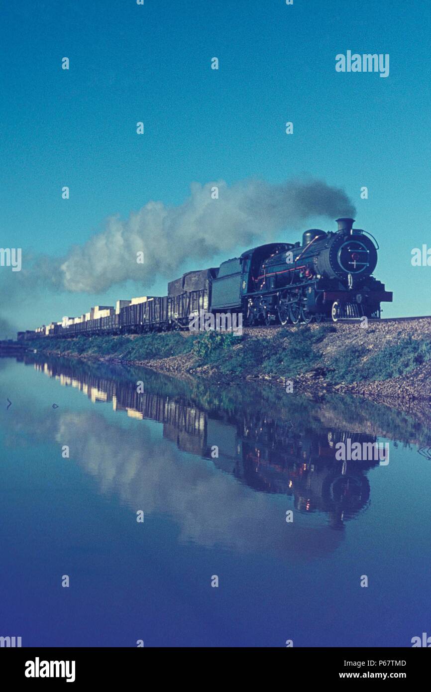 Südafrikanische Eisenbahnen 16 c Klasse Pazifik Köpfe einen Güterzug über die Gezeiten Swartkops River in Port Elizabeth am Samstag, den 7. Juli 1973. Stockfoto