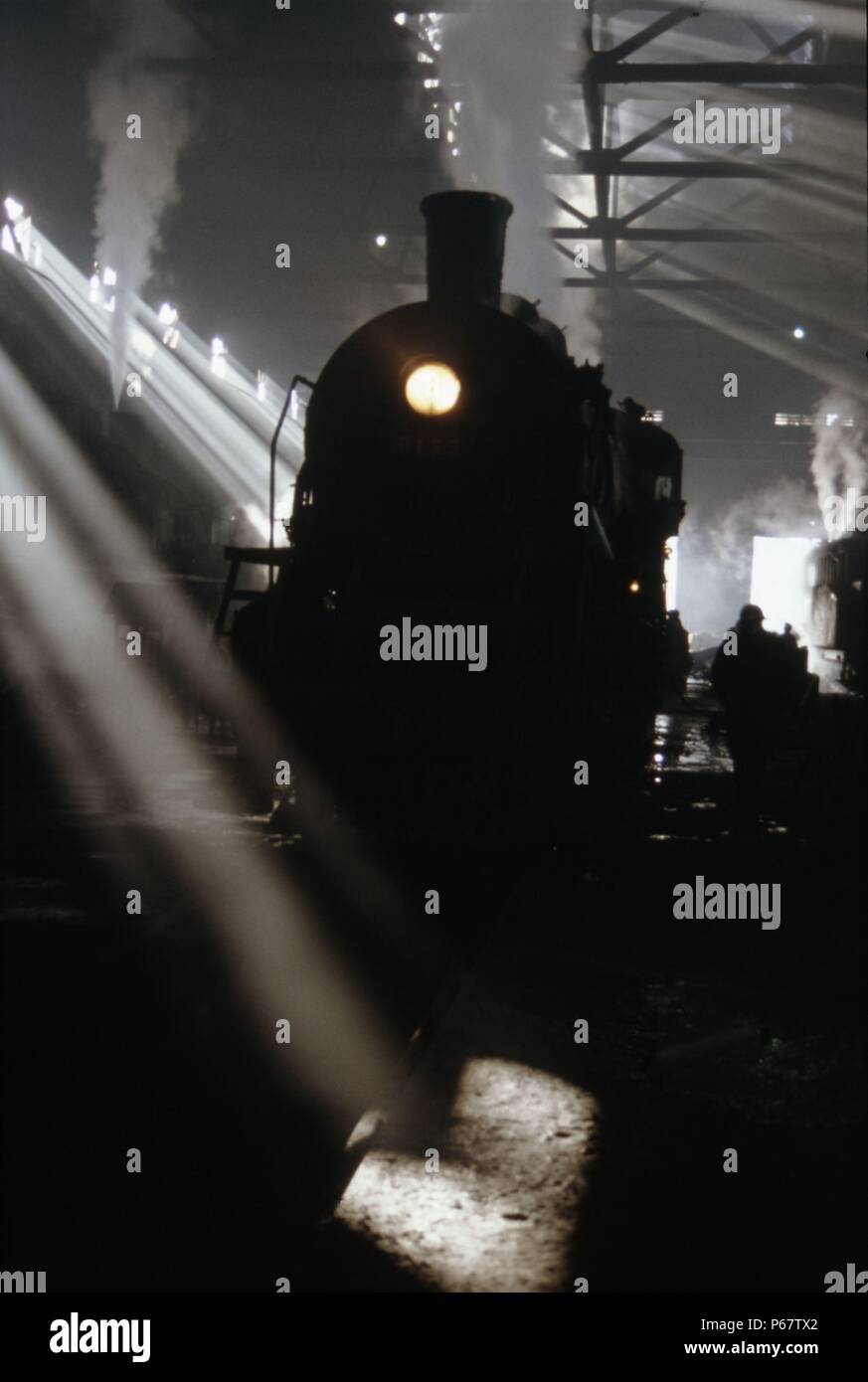 Sonnenlicht Rauch und Schatten. Eine chinesische SY Klasse industrielle Mikado 2-8-2 befindet sich inmitten der smokey Trübsinn in Anshan Iron & Steel Works Schuppen. Einige 1750 aus Stockfoto