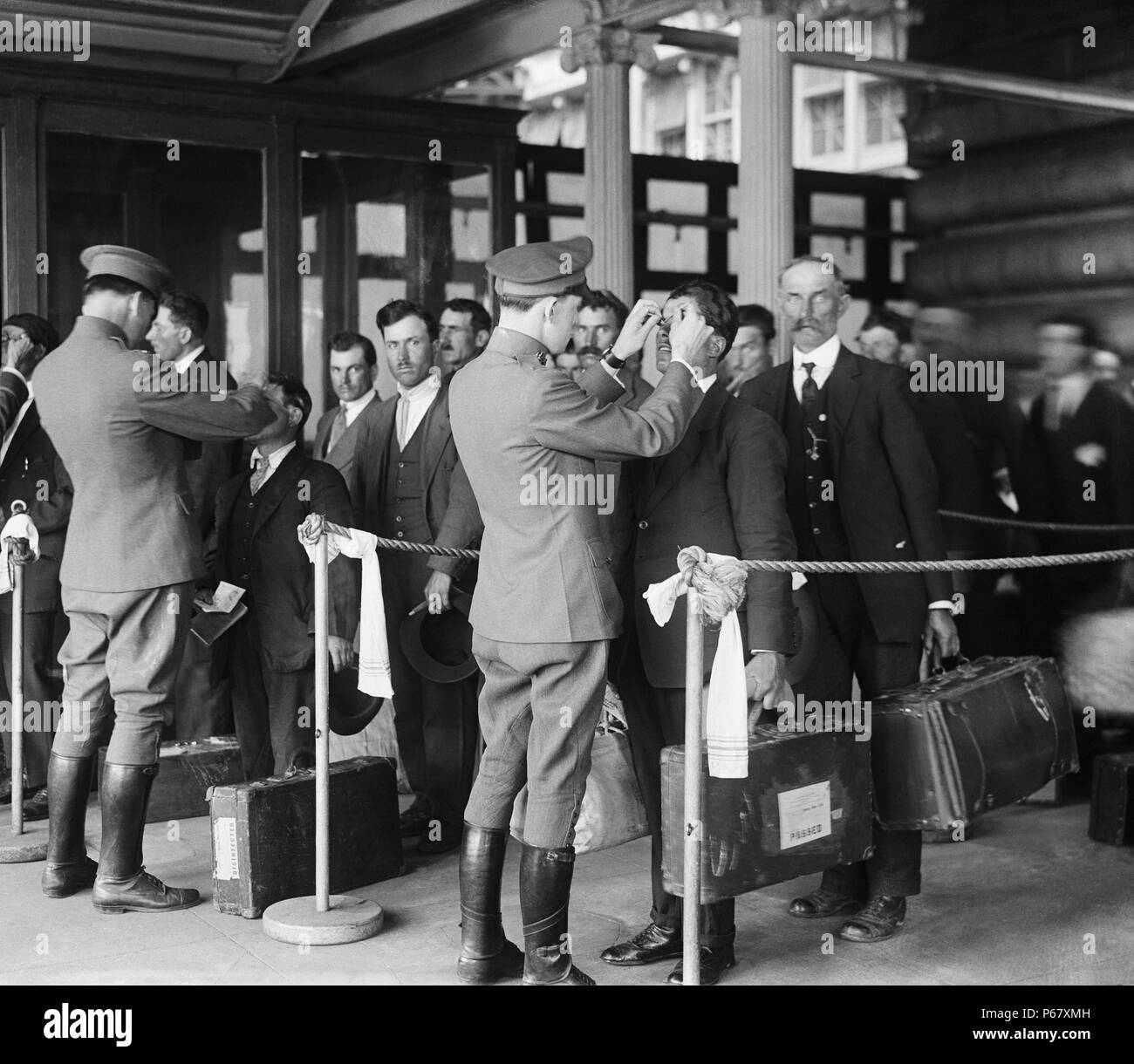 Bild zeigt ein Kontrollbesuch statt für neue Einwanderer die Einreise in die Vereinigten Staaten. Foto auf Ellis Island, New York, 1920. Stockfoto