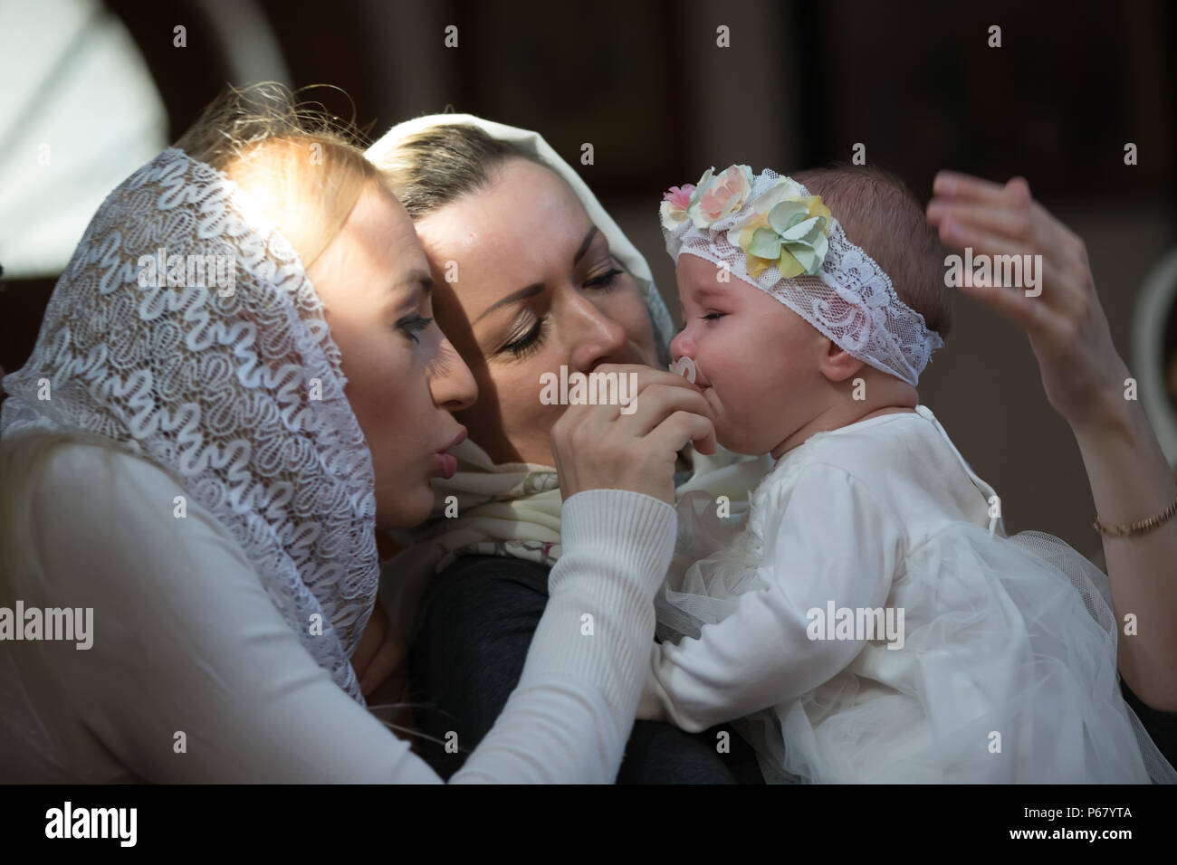 Belarus, Gomel, am 25. März. 2018. Die Prudhkovsky Kirche. Mutter und Patin in der Kirche Leid für das Kind. Der Ritus der Taufe Stockfoto