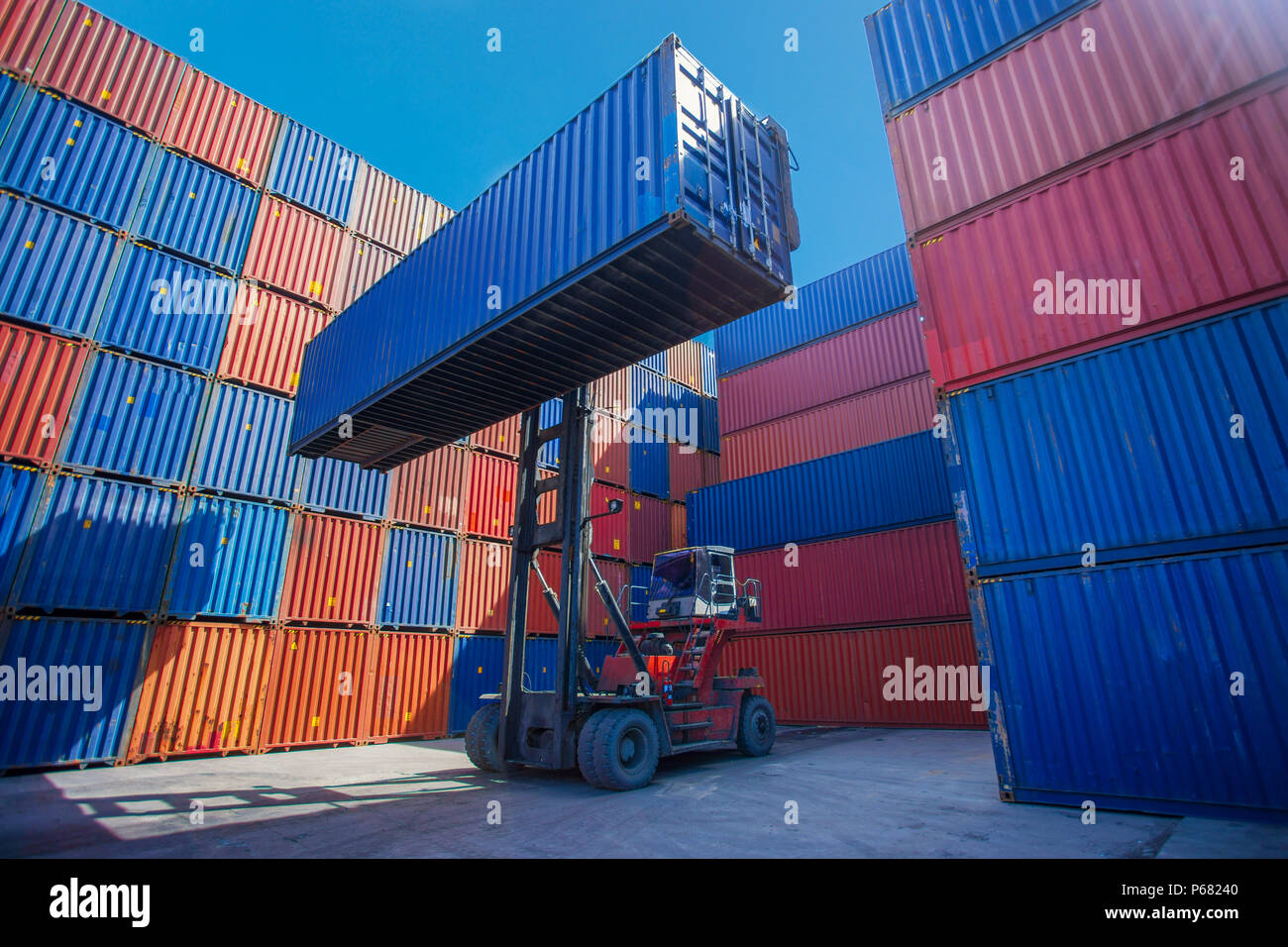 Stapler anheben Cargo Container in der Schifffahrt Yard oder Dock Yard gegen Sonnenaufgang Himmel für den Transport Import, Export und Logistik Industrie-, Bu Stockfoto