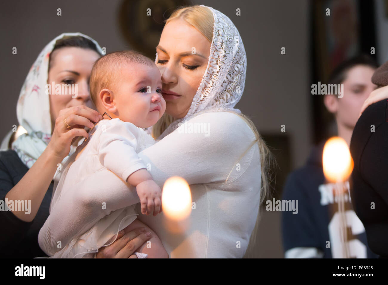 Belarus, Gomel, am 25. März. 2018. Die Prudhkovsky Kirche. Kind in die Arme der Mutter. Taufe des Babys. Akzeptieren Sie den Glauben. In der Kirche des Neugeborenen. Stockfoto