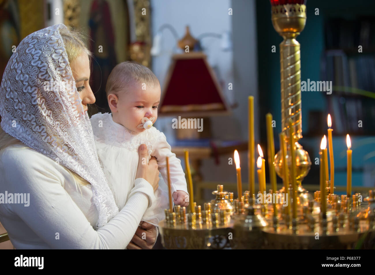 Belarus, Gomel, am 25. März. 2018. Die Prudhkovsky Kirche. Die Mutter hält das Kind auf ihren Händen im Ritus der Taufe. Akzeptieren religion Stockfoto