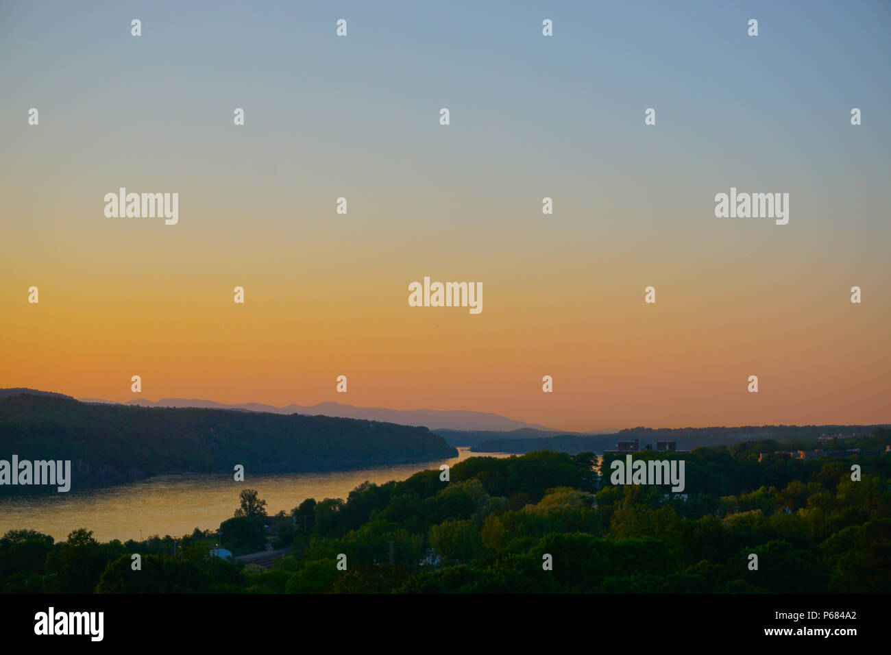 Poughkeepsie, New York, USA: Blick auf den Sonnenuntergang über dem Hudson River, mit der Catskill Mountains im Hintergrund, von dem Gehweg über den Hudson. Stockfoto