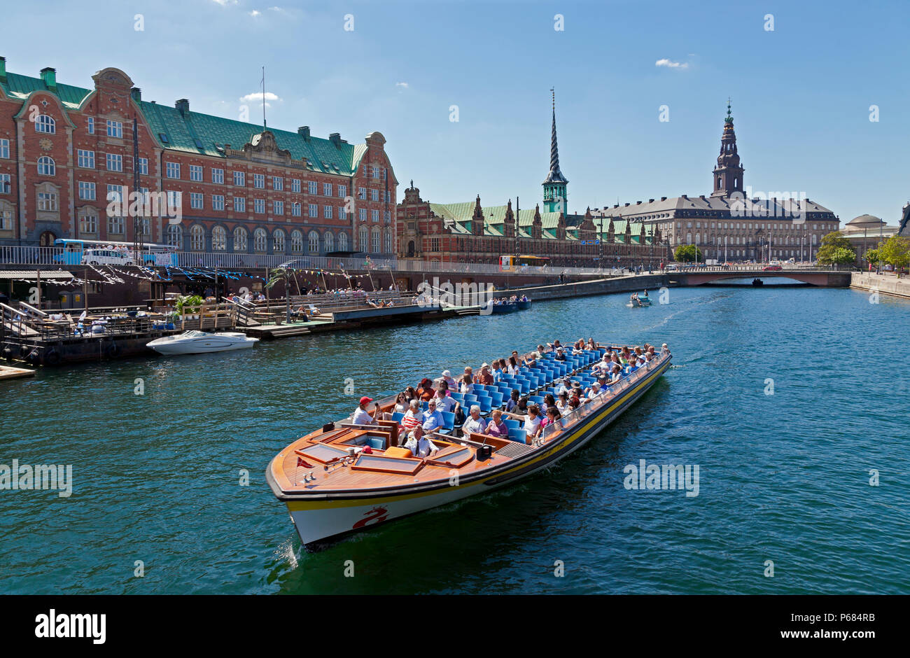 Canal Cruise Boot in Slotsholm Canal in Kopenhagen. Schloss Christiansborg, das Parlament, die alte Börse und Dockside Café- und Kajakverleih. Stockfoto