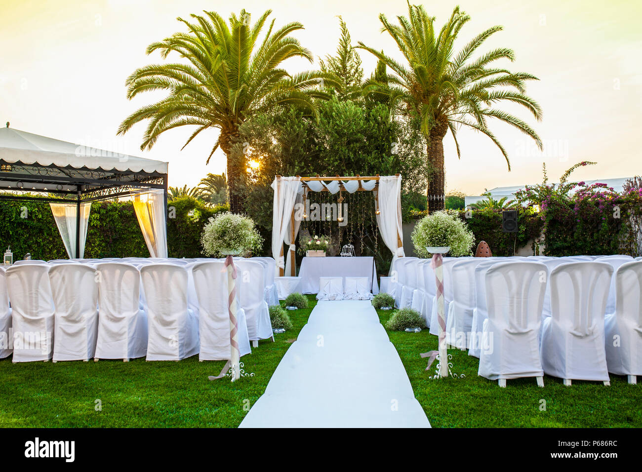 Weißer Teppich und Stühle für eine Hochzeit im Freien. Abendlicht  Stockfotografie - Alamy