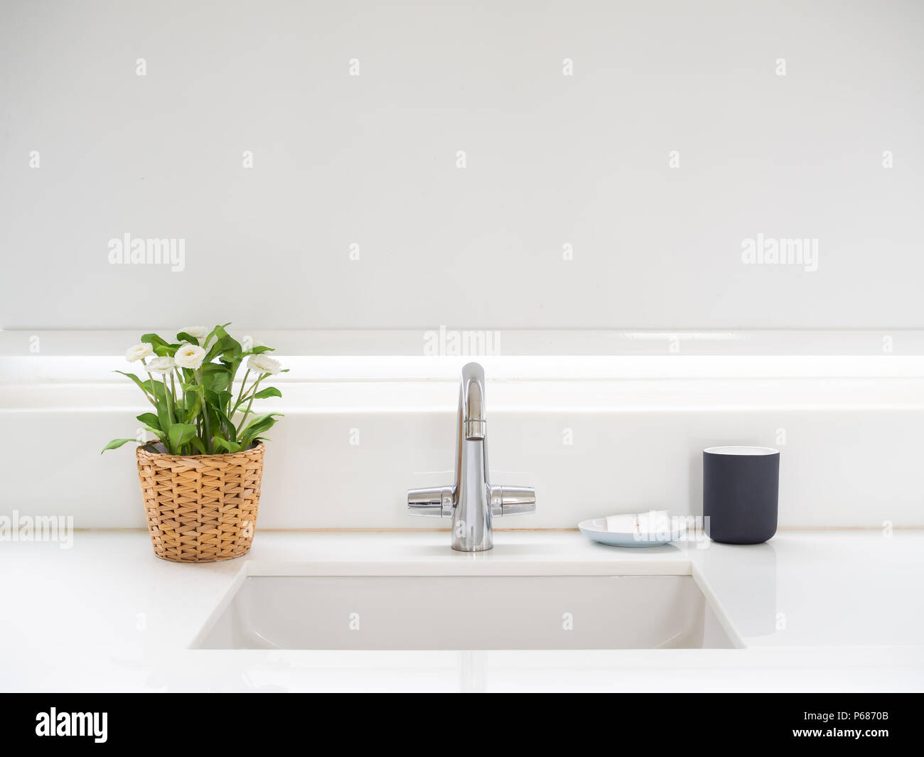 Sauberes weißes Bad mit Waschbecken Waschbecken Wasserhahn, Blumen ... Sauberes weißes Bad mit Waschbecken Waschbecken Wasserhahn, Blumen ...