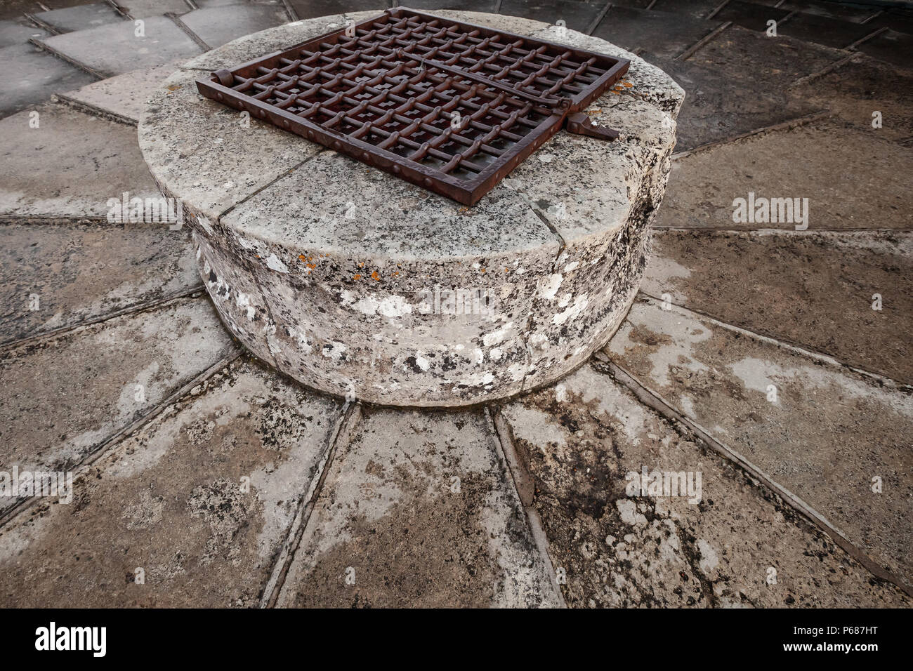 Stein gut mit rostigem Metall Gitter an der Oberseite der alten Burg Turm montiert Stockfoto