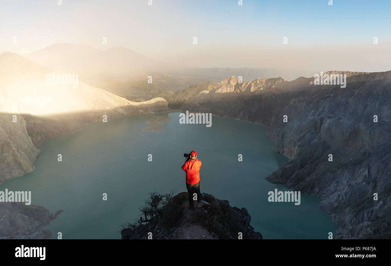 Reisende machen Fotos auf Sightseeing Punkt an Kawah Ijen vulkanischen See am Morgen, berühmten Touristenattraktion und Reiseziel in Indone Stockfoto