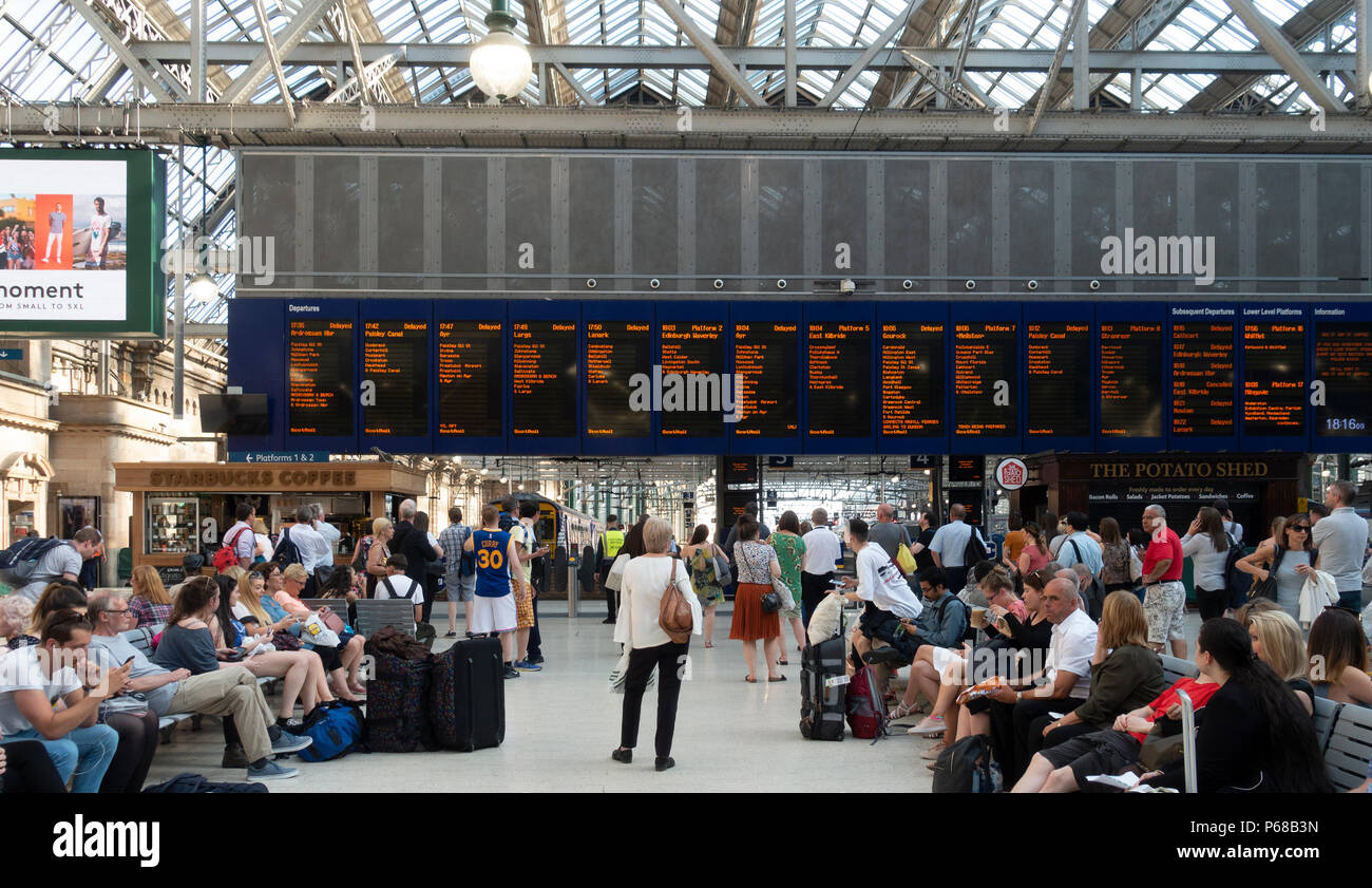 Glasgow, Schottland, Großbritannien. 28. Juni 2018. Passagiere auf dem Zusammentreffen von Glasgow Central Station warten auf Nachricht von Abflug, nach dem die meisten frühen Abend Hauptverkehrszeit Züge verzögert worden sind oder durch Signalisierung Ausfälle oder die Einführung von Geschwindigkeitsbeschränkungen aufgehoben. Stockfoto