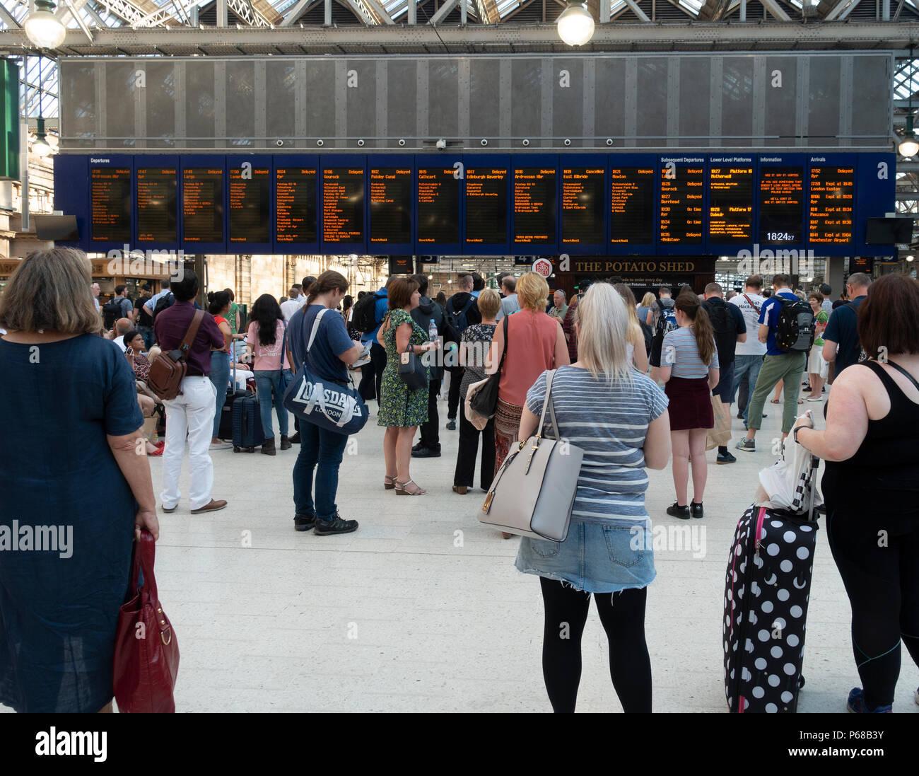 Glasgow, Schottland, Großbritannien. 28. Juni 2018. Passagiere auf dem Zusammentreffen von Glasgow Central Station warten auf Nachricht von Abflug, nach dem die meisten frühen Abend Hauptverkehrszeit Züge verzögert worden sind oder durch Signalisierung Ausfälle oder die Einführung von Geschwindigkeitsbeschränkungen aufgehoben. Stockfoto