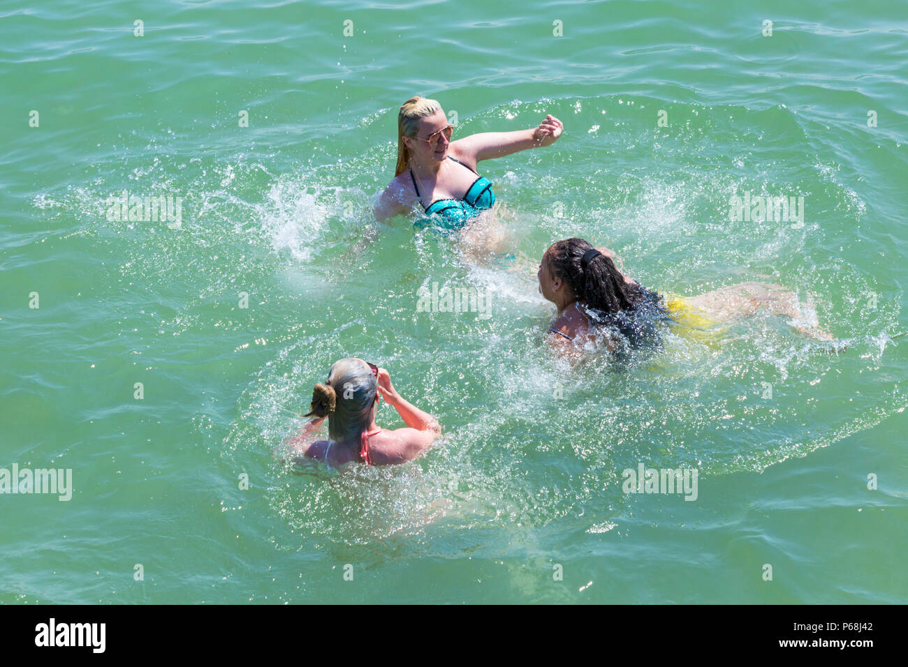 Bournemouth, Dorset, Großbritannien. 29 Juni, 2018. UK Wetter: sunseekers Kopf bis zu den Stränden von Bournemouth auf einen weiteren sonnigen Tag mit Ungebrochenen blauer Himmel und Sonnenschein. Eine leichte Brise die Hitze erträglicher macht. Drei junge Frauen im Meer. Credit: Carolyn Jenkins/Alamy leben Nachrichten Stockfoto