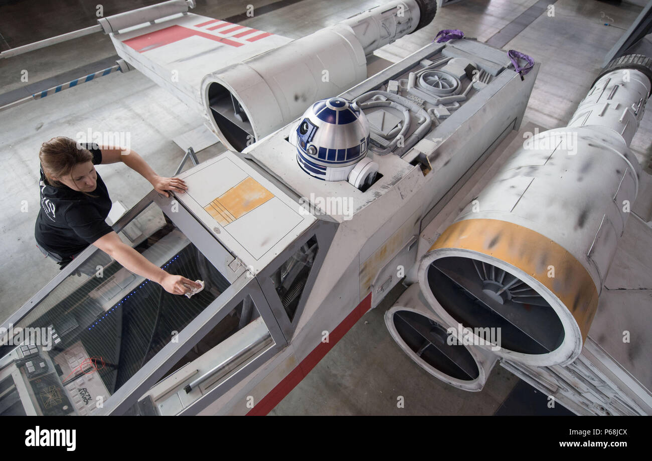 Stuttgart, Deutschland. 29 Juni, 2018. Ein Mitglied einer Fan Projekt Reinigung die Rekonstruktion einer "X-Wing" Raumschiff aus dem Film Star Wars Saga während des Set-up Der pop kultur Messe "Comic Con Deutschland'. 'Comic Con Deutschland' läuft vom 30. Juni bis 01. Juli 2018. Credit: Marijan Murat/dpa/Alamy leben Nachrichten Stockfoto
