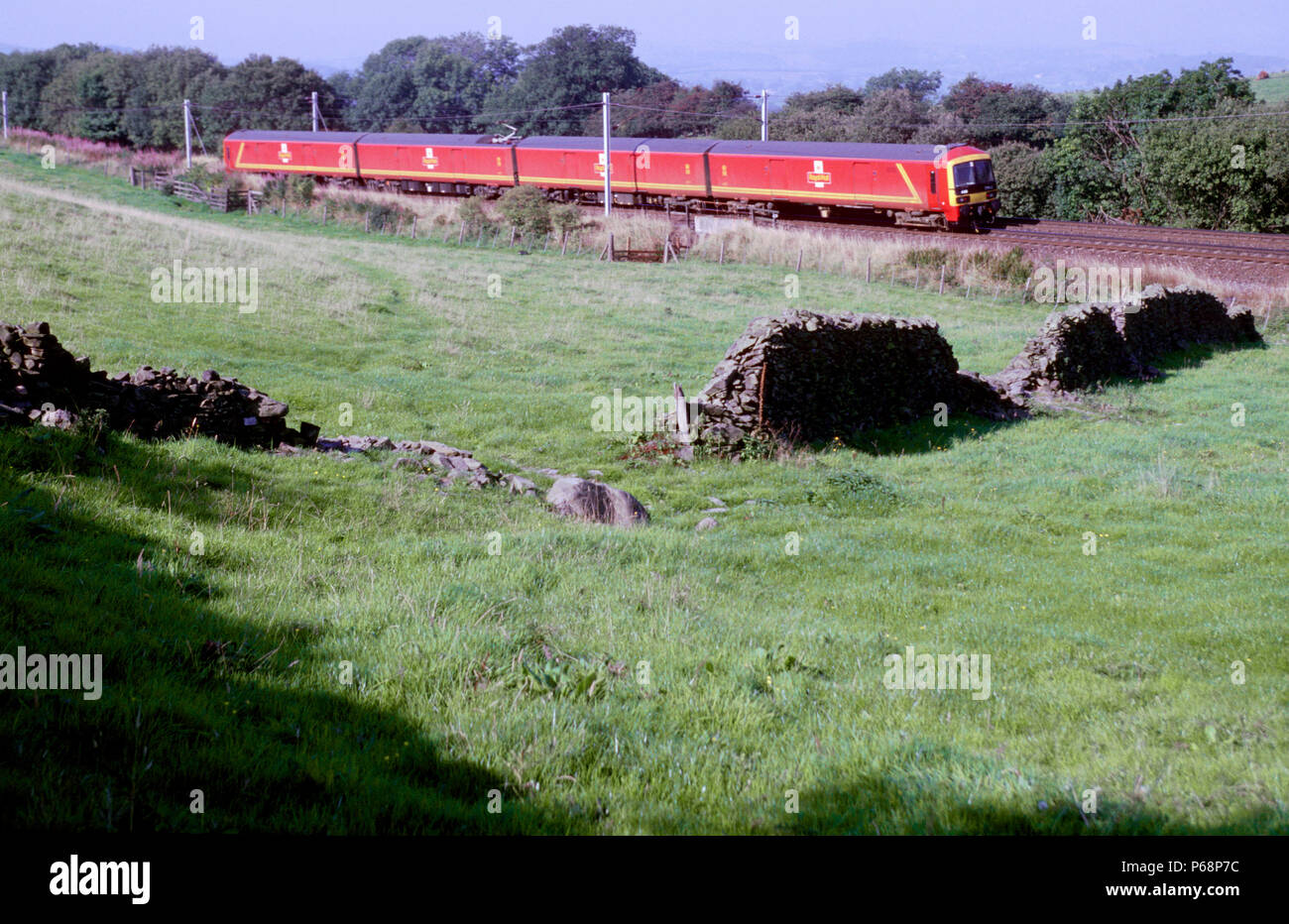 Die Royal Mail Flotte der Klasse 325 Einheiten sind die wwu Züge von EWS betrieben im Namen von Royal Mail wie dieses Zuges racing nördlich durch den See Stockfoto