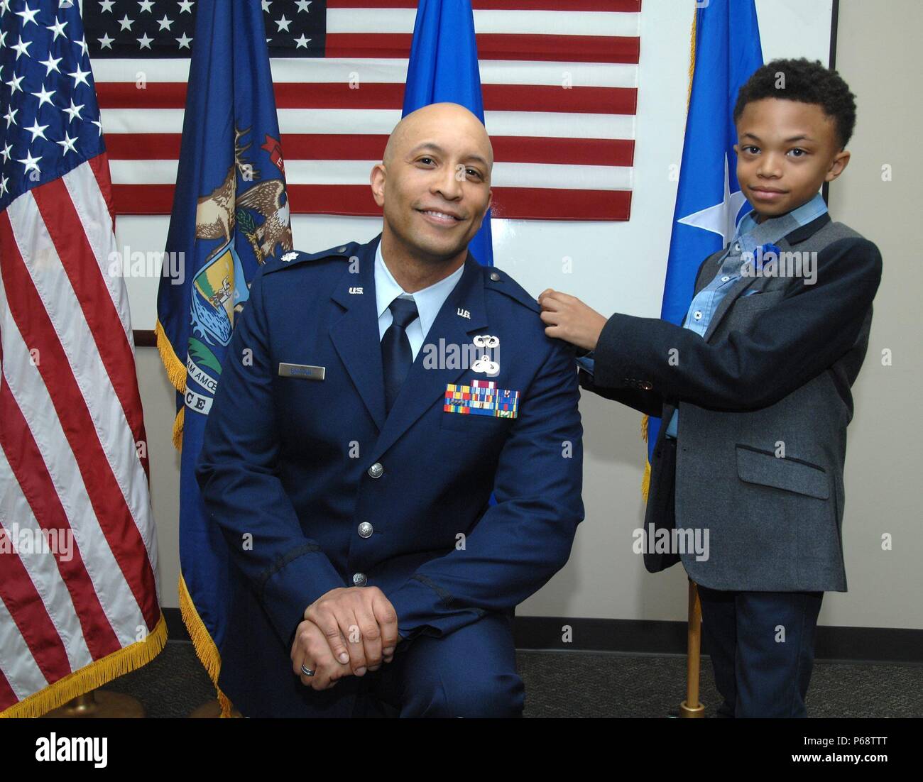 Derrick Britton von Flint, Michigan, wurde zum Oberstleutnant der Reserve Offizier der United States Air Force und die Michigan Air National Guard, 28. April 2016 gefördert. Sein Sohn, Elia, unterstützt mit einheitlichen Anpassungen. Britton ist zur Lansing zugewiesene Joint Forces Headquarters aber derzeit für staatliche Active Duty Bestellungen Feuerstein Bewohner während der Wasserkrise zu dienen. (U.S. Air Force Foto von Master Sgt. Denice Rankin/Freigegeben) Stockfoto