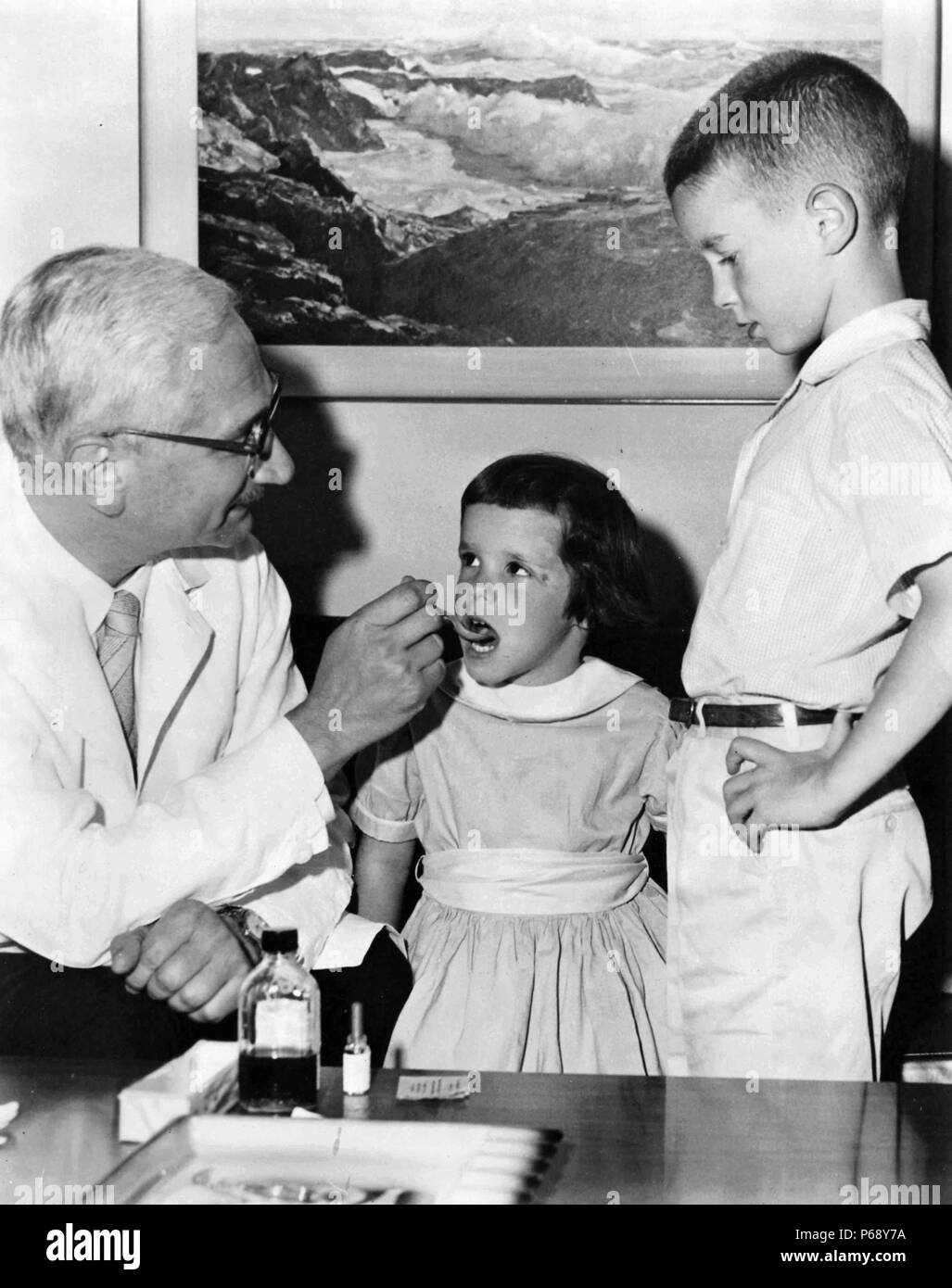 Foto von Albert Bruce Sabin (1906-1993) ein Jüdisches polnische Amerikanische medizinische Forscher, am besten in einer oralen Polio-Impfstoff entwickelt bekannt. Dr. Albert Sabin ist hier gesehen Gabe von oralen Polio virus Impfstoff zu zwei Kinder. Vom 1966 Stockfoto