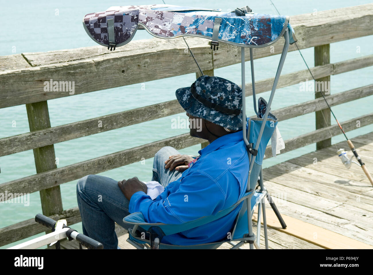 Man entspannt sich im Stuhl auf Pier in Myrtle Beach State Park, SC, USA. Stockfoto