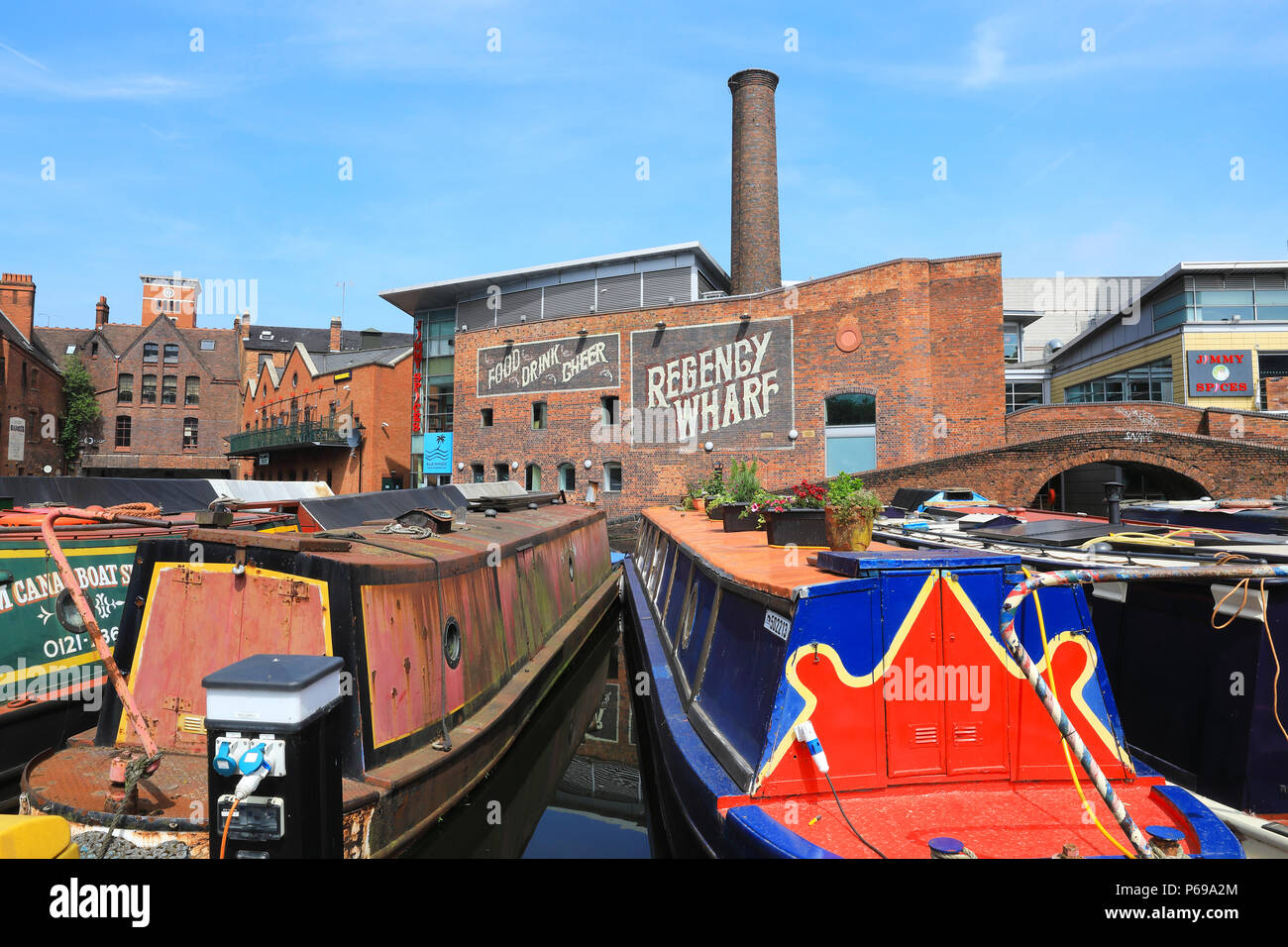 Die bunten Boote und Kähne an der Rückseite des Regency Wharf Entwicklung auf dem Gas Street Basin in Birmingham, in den West Midlands im Vereinigten Königreich Stockfoto