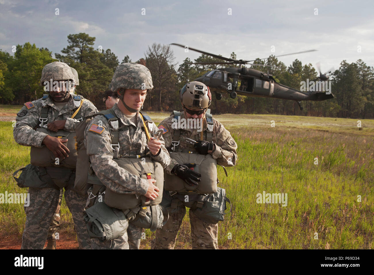 Us-Armee Fallschirmjäger Chief Warrant Officer 5 Travis und sein Sohn, Pvt. Travis, weg von einem UH-60 Blackhawk drehen wie es landet vor dem Einstieg in das Flugzeug für einen Betrieb in Fort Bragg, N.C., 5. Mai 2016. Die U.S. Army Special Operations Command (USASOC) und der Army Special Operations Aviation Befehl (ARSOAC) wurden Hosting ein Sprung über den St. Mere Eglise Drop Zone zu gedenken Gesetz Tag und Währung in der kontingenz Missionen zu erhalten. (U.S. Armee Foto von SPC. Rachel Diehm/Freigegeben) Stockfoto