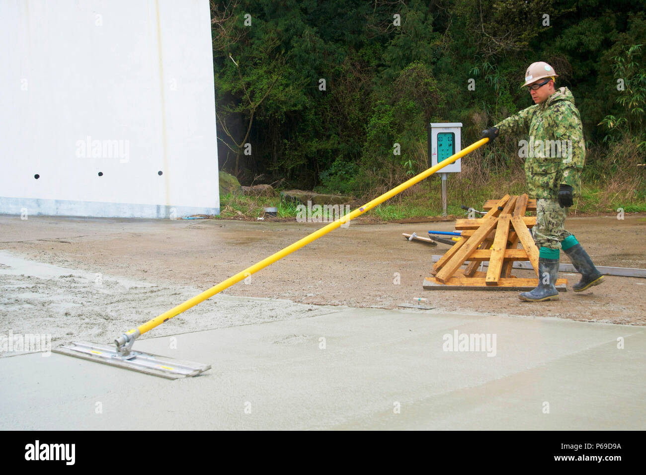 160403-N-NE 195-004 YOKIJIDO ISLAND, Republik Korea (Apr. 3, 2016) - Beim Bau einer Straße Projekt auf Yokjido Insel in der Republik Korea, Builder 1. Klasse Oscar Barba, zugeordnet zu den Naval Mobile Konstruktion Bataillon (NMCB) 4 Ende der Oberfläche auf der Straße durch Glättung der Oberfläche von nassem Beton mit einem Stier float 26.04.3. Der letzte Schliff wie diese eine glatte Oberfläche erstellen und die Straße geben, eine hohe Qualität und professionelles Aussehen. Nach Abschluss der asphaltierten Straße wird der Abstand von 2.000 Menschen effizienter zu verbinden waren zu verkürzen, Stockfoto