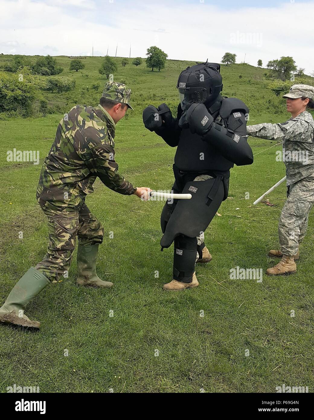 Cpl. Vliad Gendarmerieuniform für rumänische Landstreitkräfte zugeordnet, Praktiken Baton einzigen Streik Techniken während eines mock riot control Übung in Cincu Training Strecke, Rumänien am 10. Mai 2016. Demonstration im "Red Man"-Anzug" ist Spc. Landon Glover, Militärpolizei mit 1165Th Military Police Company und Unterstützung als Spotter ist Sgt. Randi Biggs, Militär, Polizei mit den 231St Military Police Bataillon, Alabama National Guard. (U.S. Armee Foto vom Kapitän Ryan E. Schwarz, 877Th Engineer Battalion, Alabama National Guard) Stockfoto