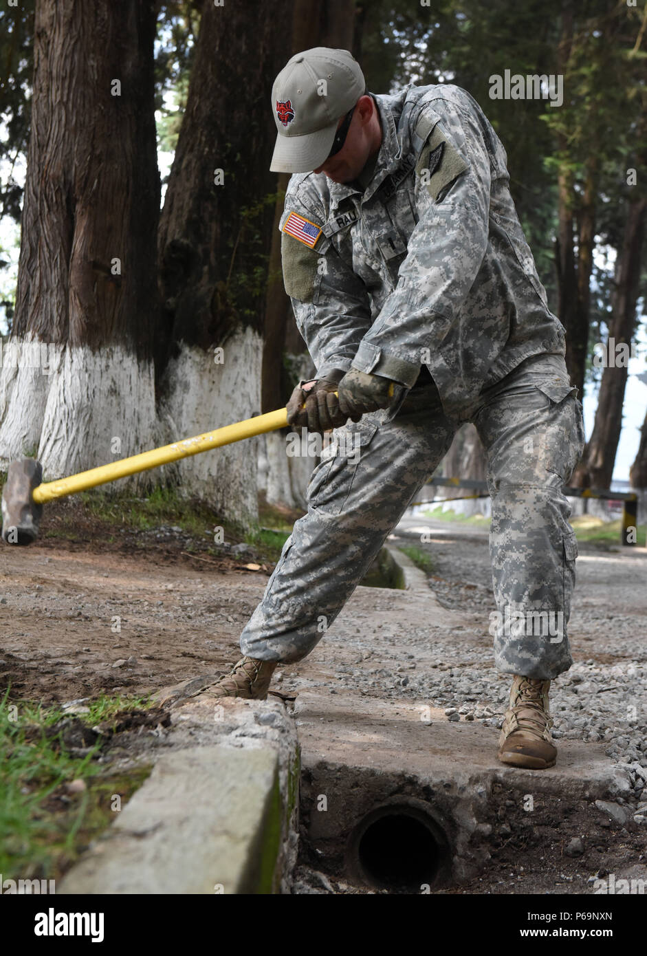 SAN MARCOS, Guatemala - US Army 1st Lieutenant Walter Rau, Task Force rote Wolf Bürgermeister, zerschlägt ein zerbrochenes Stück Beton mit einem Vorschlaghammer 28. Mai 2016, während der Übung über den Horizont 2016 GUATEMALA. Forward Operating Base Alpha ist die Durchführung der Restaurierung Projekte vor der Task force fährt Mitte Juni. Stockfoto