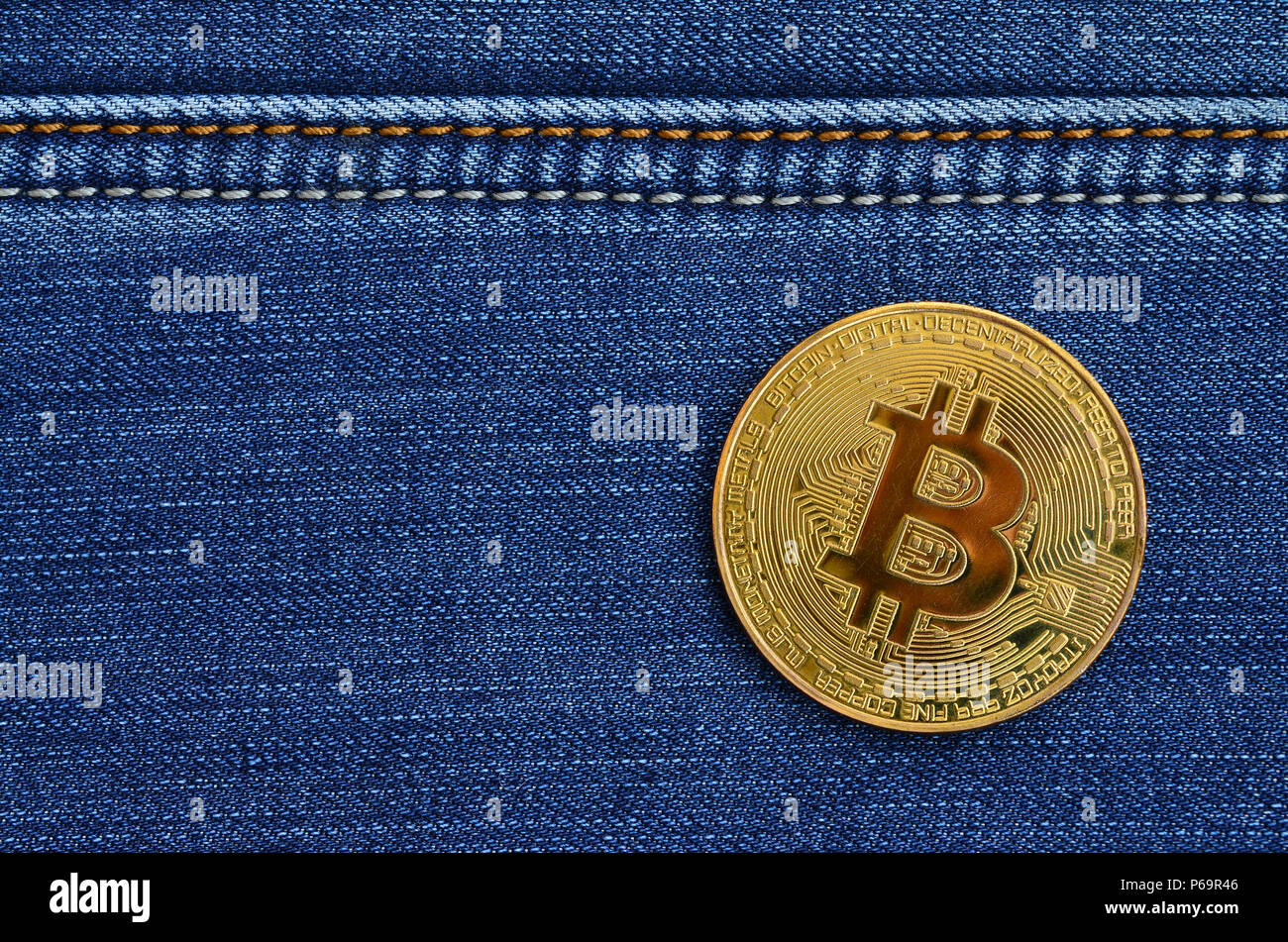 Golden Bitcoin liegt auf einer blauen Jeans Stoff. Neue virtuelle Geld. Neue crypto Währung in Form der Münzen. Stockfoto