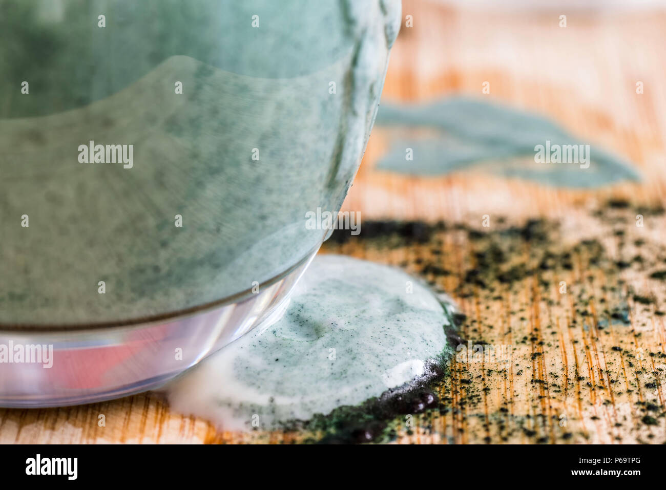 Detailansicht frischen Kefir probiotik Drink tauchte von überfüllt Glas dort mit Grün spirulina Pulver am Küchentisch gemischt wurde. Stockfoto
