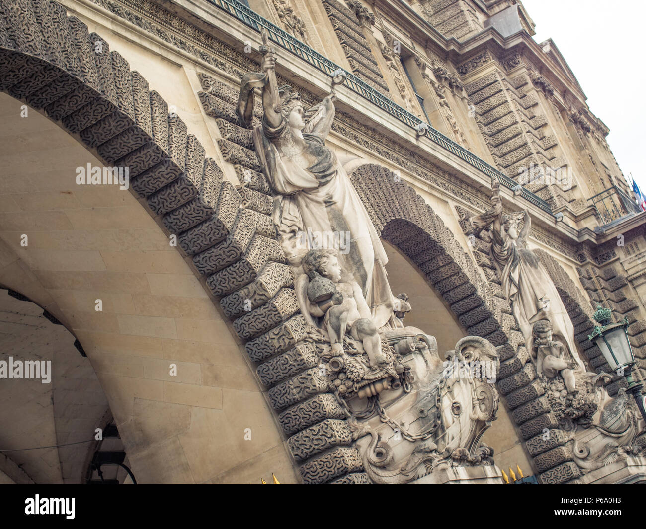 Steinernen torbogen an den Informationsschaltern du Louvre mit François's Jouffroy weibliche Skulpturen aus Stein Marine Guerrière und Marine Marchande in Paris, Frankreich. Stockfoto
