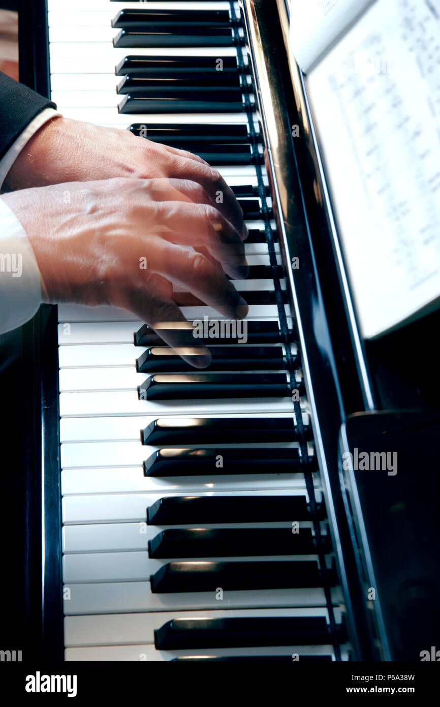 Hände über Piano keys in Zeitlupe Erstellen eines Ghost Wirkung gleiten. Stockfoto
