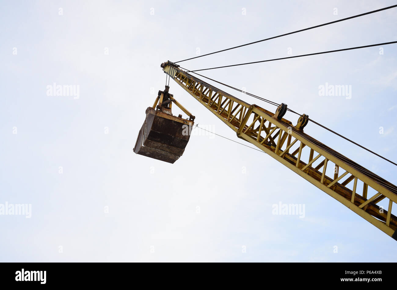 Alte gelbe mechanische Greifer Greifer auf blauen Himmel Hintergrund. Stockfoto