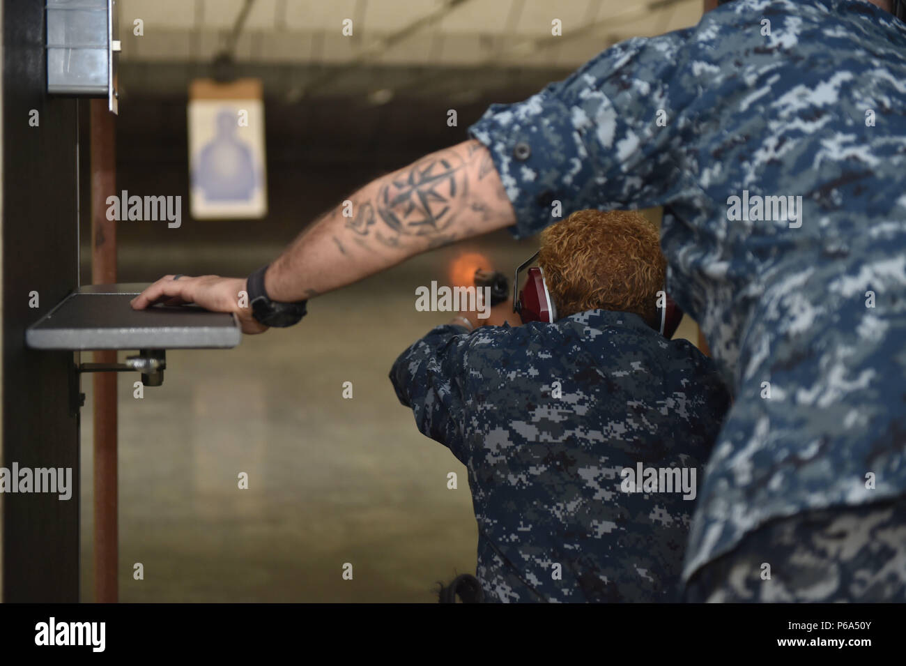 160527-N-OO 032-063 SILVERDALE, Washington (27. Mai 2015) - Manpower, Personal, Aus- und Weiterbildung Fuhrpark Master Chief April D. Beldo, Lancaster, Kalifornien native feuert eine 9 mm Hand Waffe auf einen 15 Yard Ziel mit ihren Linie Reisebus, Chief Mineman Yancy Forbes, ein Manistee, Michigan Eingeborener, während einer Naval Hand Gun Qualifikation Kurs am Marinestützpunkt Kitsap's Small Arms Training Center. Beldo bereiste den $ 12,5 Mio. bei einem Besuch im pazifischen Nordwesten. (U.S. Marine Foto von Mass Communication Specialist 2. Klasse Cory Asato/Freigegeben) Stockfoto