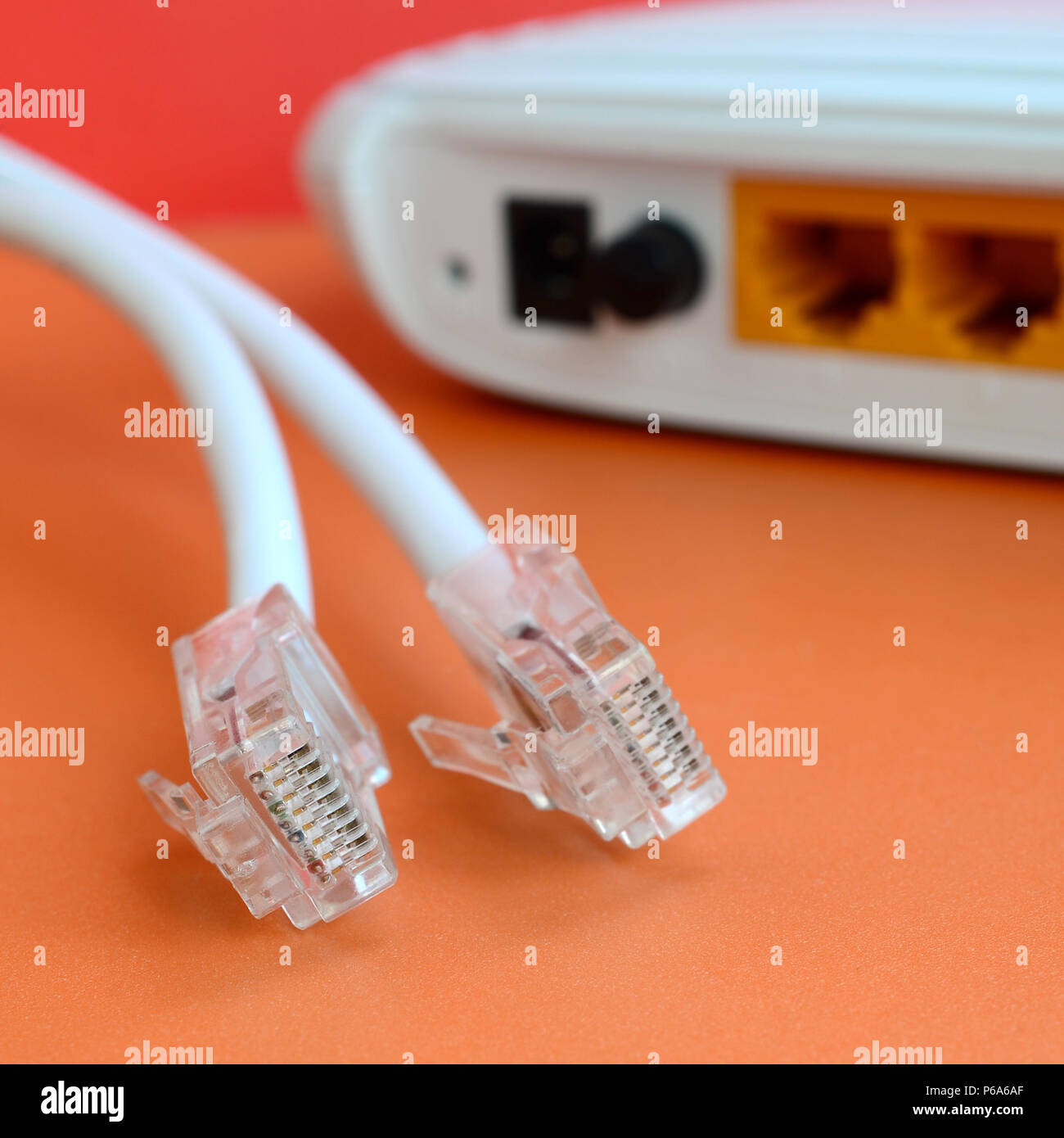 Internet Router und Internet Kabel Stecker liegen auf einem hellen orange  hinterlegt. Elemente für Internetverbindung erforderlich Stockfotografie -  Alamy