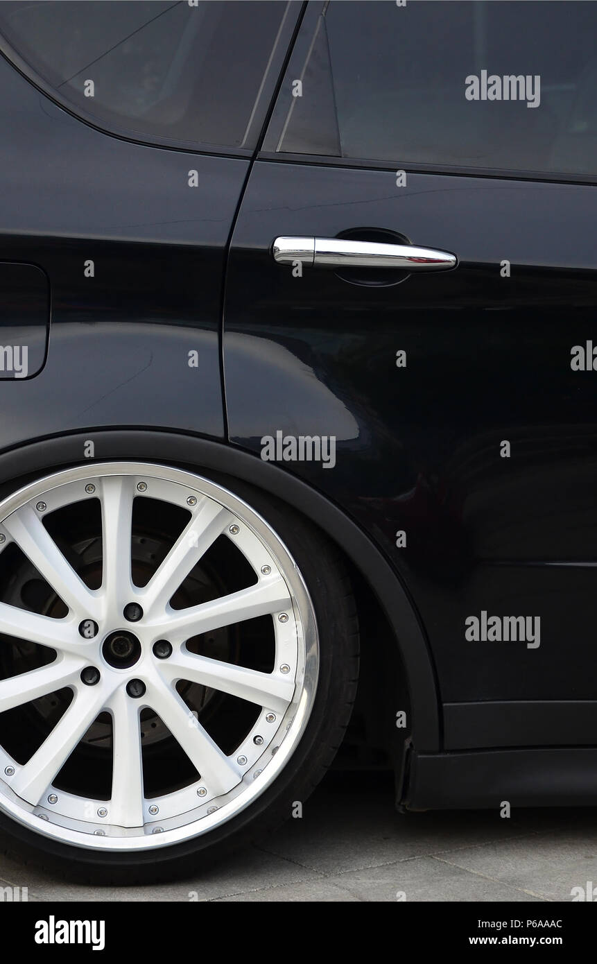 Seitenansicht eines schwarz glänzend Auto mit weißen Felgen Stockfotografie  - Alamy