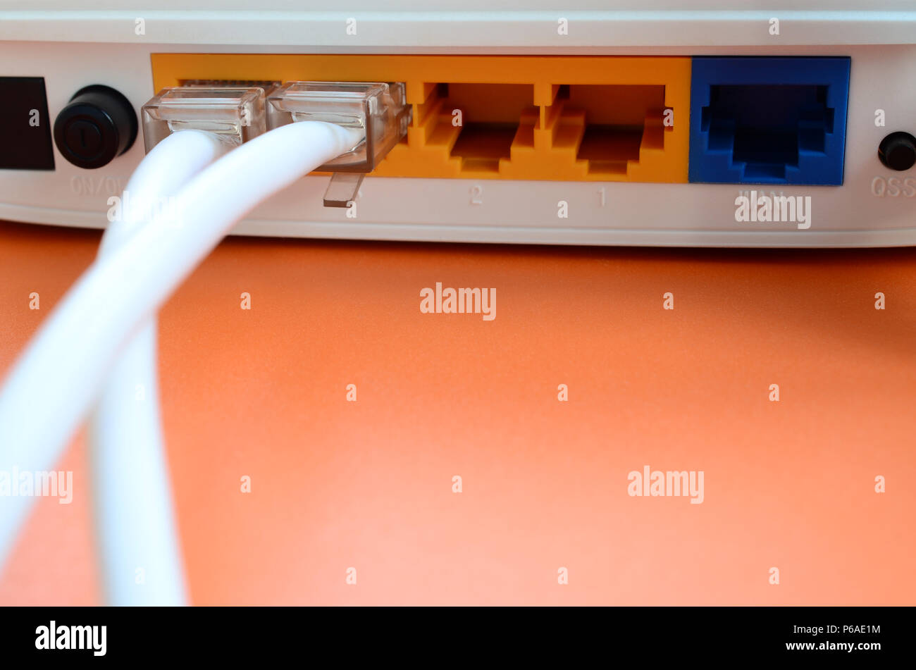 Das Internet Kabel Stecker sind mit dem Internet Router, der für ein helles  orange Hintergrund verbunden. Elemente für Internetverbindung erforderlich  Stockfotografie - Alamy