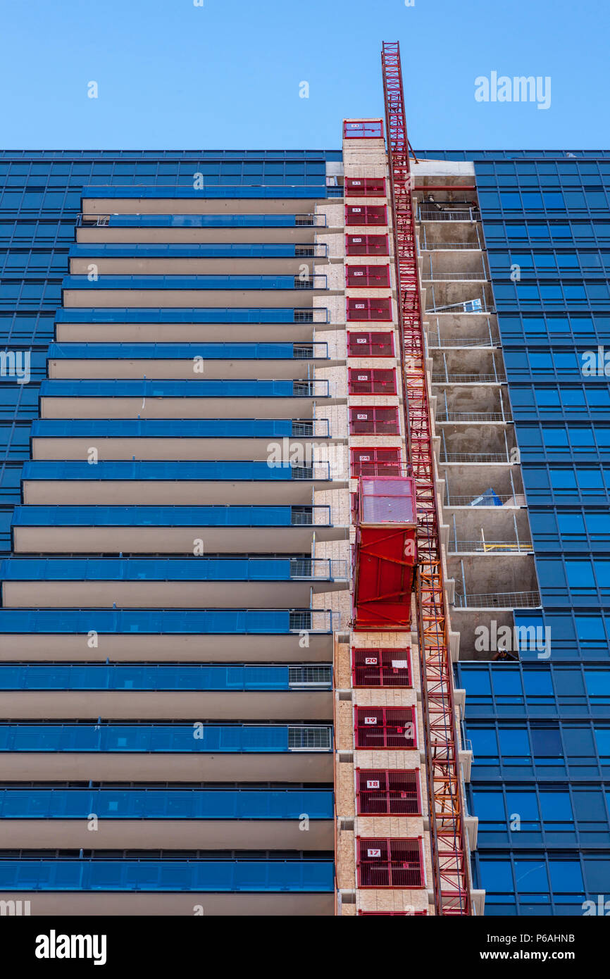 Bau Aufzug auf der Seite der ein modernes Gebäude aus Glas, die im Bau ist. Stockfoto